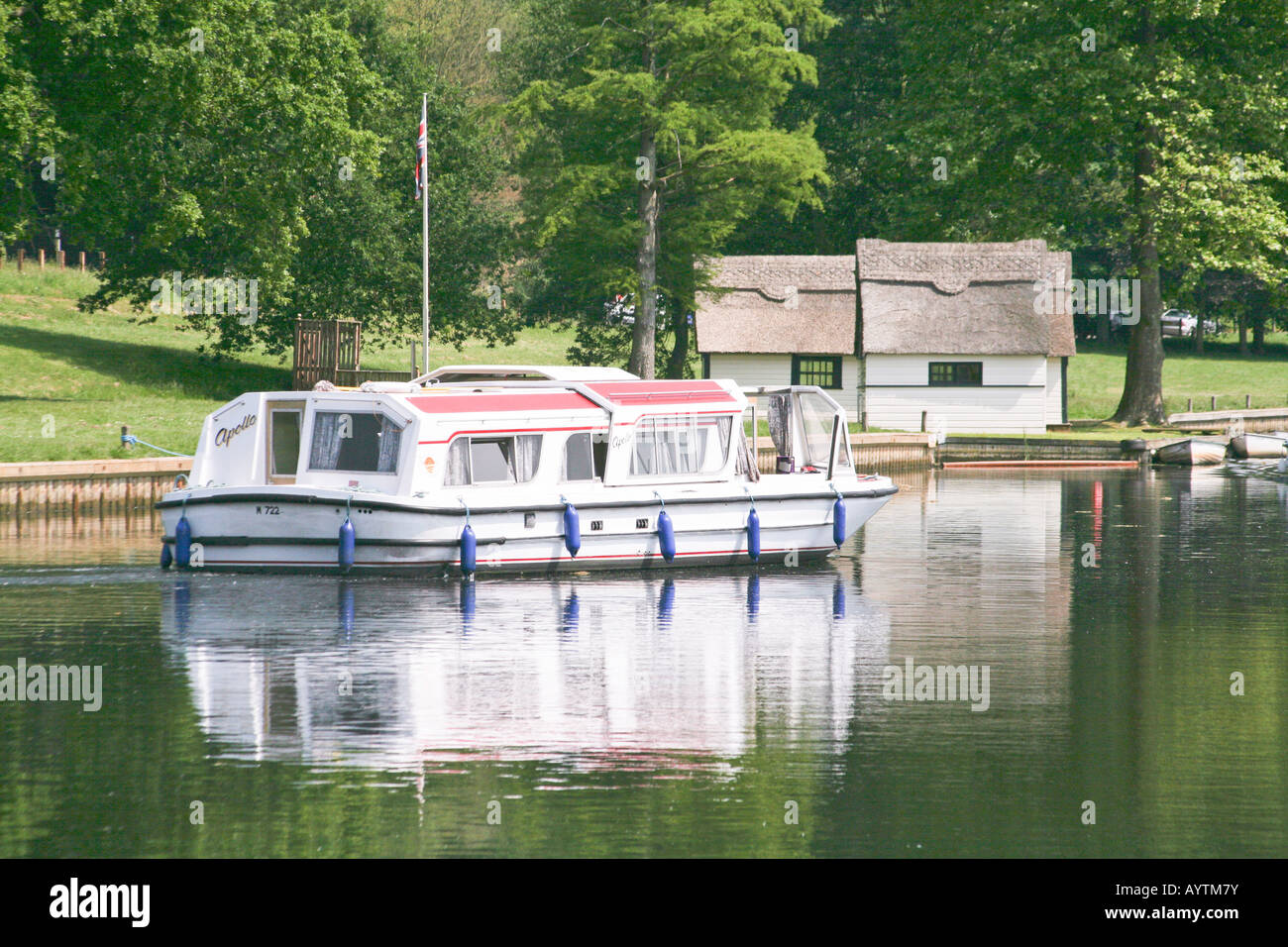 Broads Cruiser auf den Norfolk Broads an Coltishall Norfolk in England mit Werksbrücke und Bäumen Stockfoto