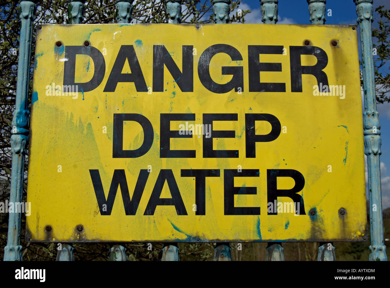 Gefahr tiefen Wasser, ein Warnschild mit schwarzem Text auf gelbem Hintergrund von Fluß Themse, Kingston, Surrey, england Stockfoto