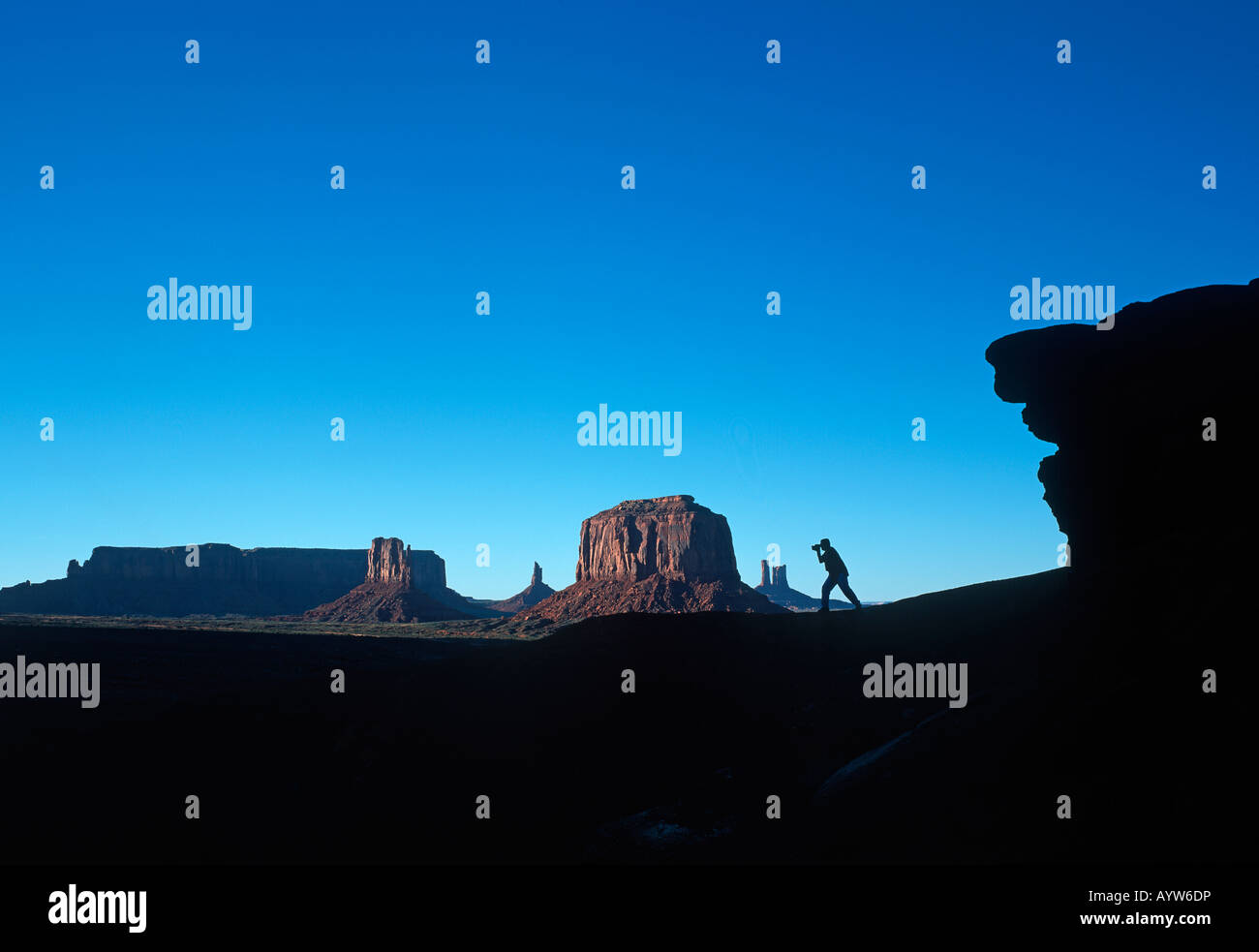 Silhouette Tourist soll die landschaftlich reizvolle Ausblicke des Monument Valley in den amerikanischen Westen von Nordarizona fotografieren Stockfoto