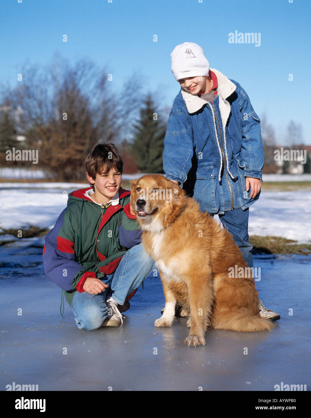 zwei jungen mit einem Hund auf einer Eisfläche, Eisfläche, Eisdecke, Winter, winterliche, Winter Kleidung, winter, Kleidung, Wollmütze, Kind, Kinder, Tierwelt Stockfoto