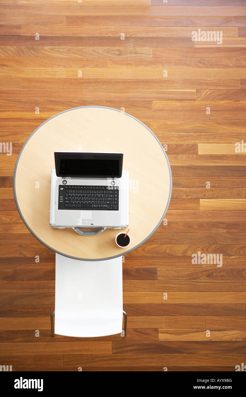 Runder Tisch mit Notebook auf und Stuhl im hohen Winkel Stockfoto