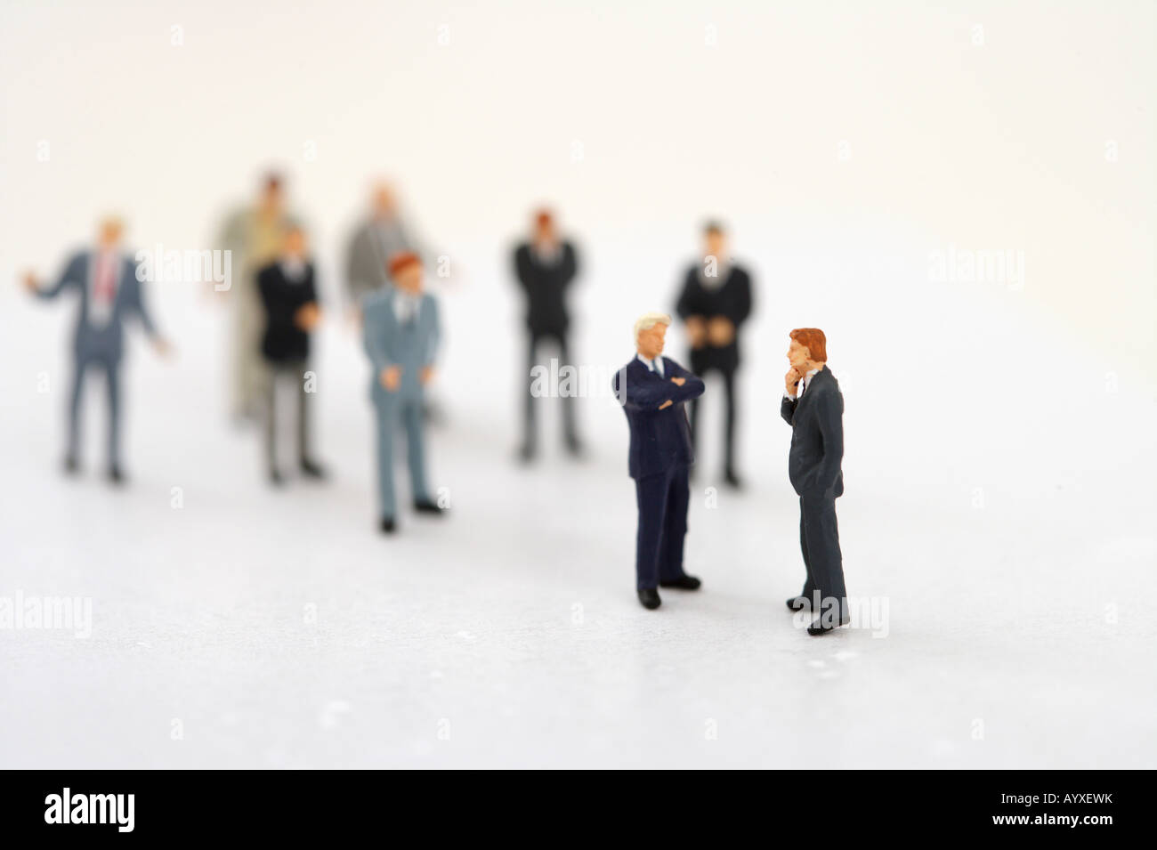 Zwei Geschäftsleute Figuren sprechen, andere, im Hintergrund Stockfoto