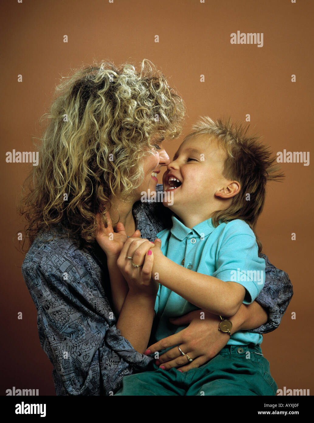 Kleiner Junge Sitzt Auf Dem Schoss der Mutter, Beide Lachen Sich ein Stockfoto