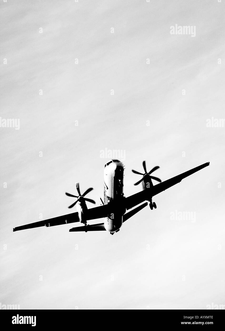 Ein Porträt Format Bild ein Twin Propeller Flugzeuge im Endanflug in schwarz und weiß zu landen. Stockfoto
