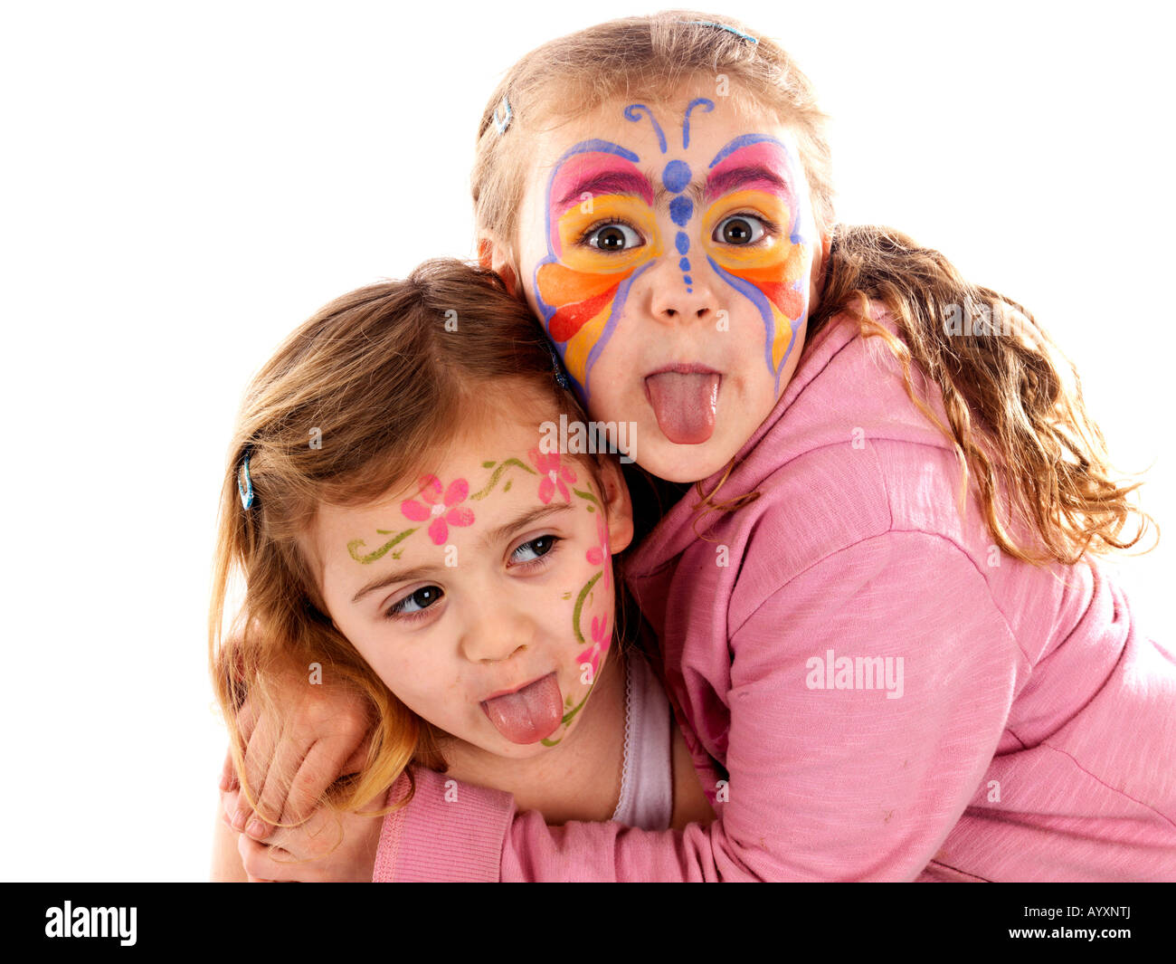 Verspielte Glückliche junge Kinder oder Schwestern mit bunt bemalten Gesichtern Spaß isoliert gegen einen weißen Hintergrund mit einen Freistellungspfad Stockfoto