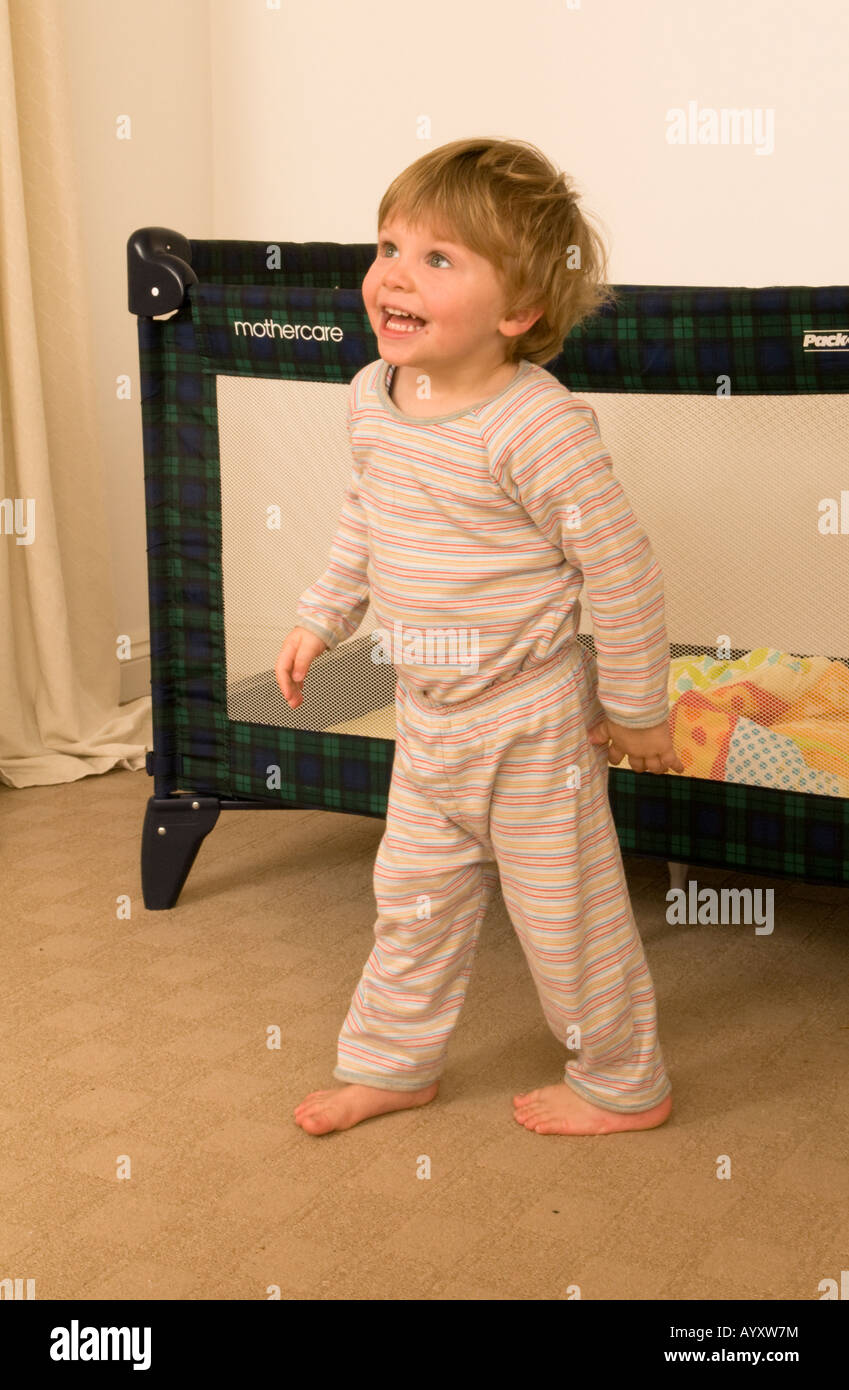 Der zweijährige Junge ist gerade aus dem Bett geklettert, der mit sich zufrieden aussah Stockfoto