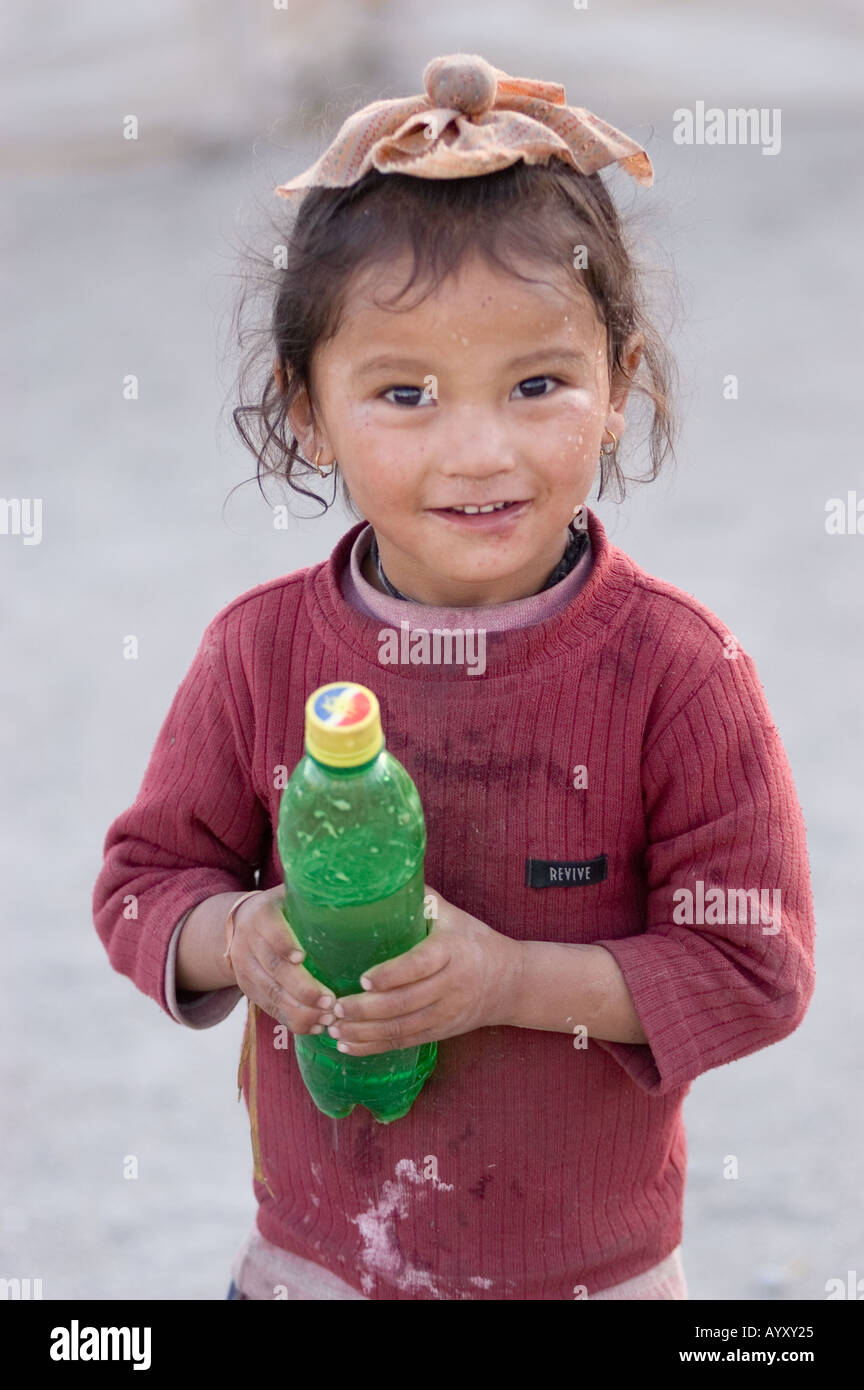 Ladakhi junge Mädchen mit Sprite Plastikflasche Blick in die Kamera und lächelnd Leh Ladakh Indien Stockfoto