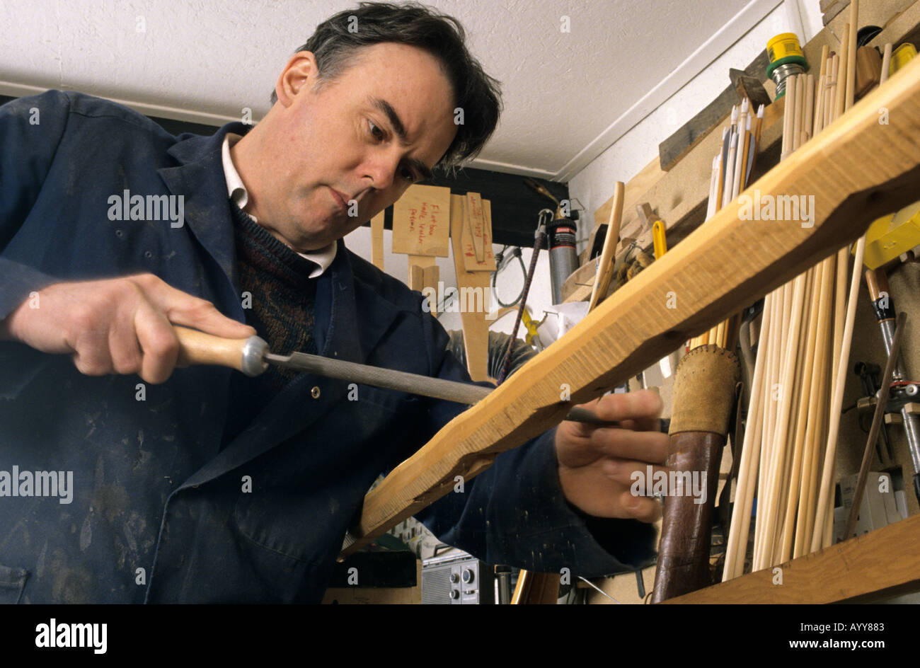 Pfeil und Bogen-Hersteller glätten das Holz auf einen Langbogen mit einer Raspel Stockfoto