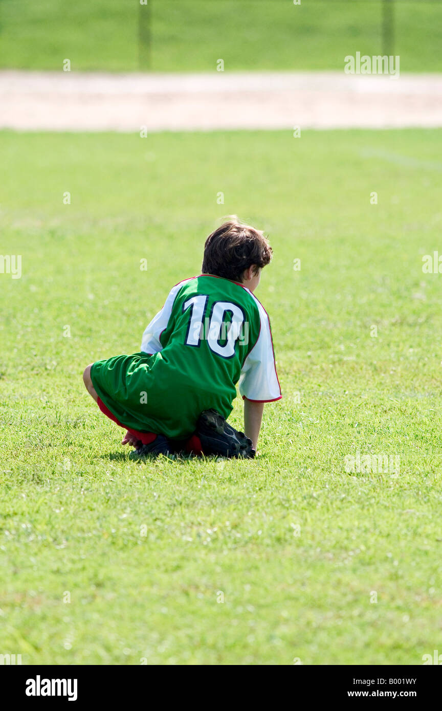 9-jähriger Junge bückte sich verletzt Fußball spielen Stockfoto