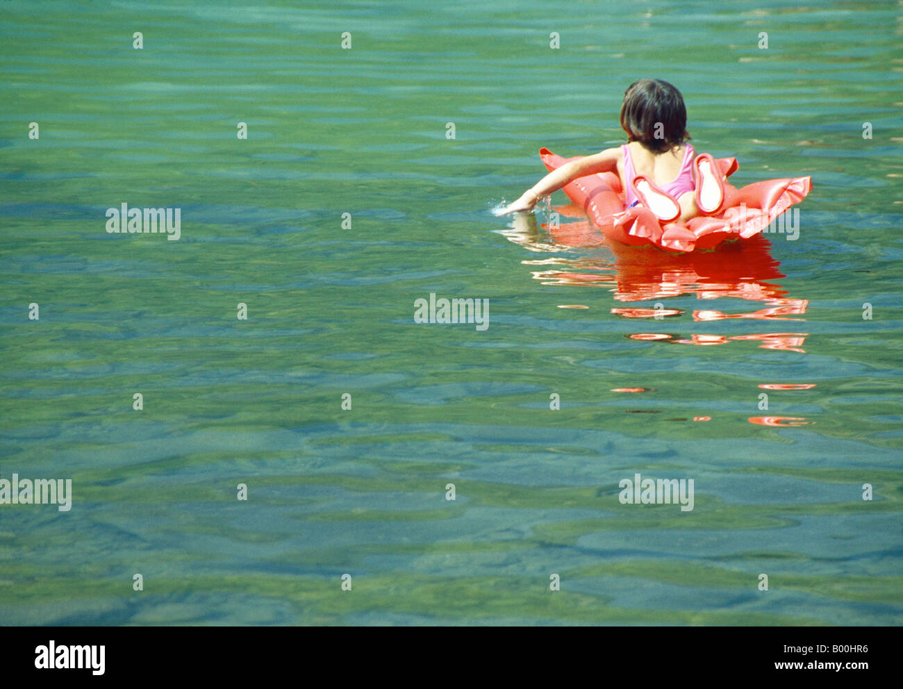 Mädchen auf einer Luftmatratze auf dem Wasser. Lago de Sanabria Nature Reserve. Provinz Zamora. Kastilien-León. Spanien. Stockfoto