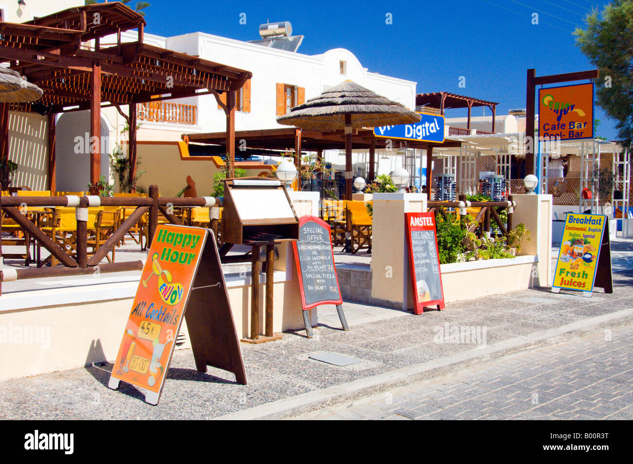 Restaurants und Geschäfte mit Blick auf den schwarzen Sandstrand in Kamari auf der griechischen Insel Santorini Griechenland Stockfoto