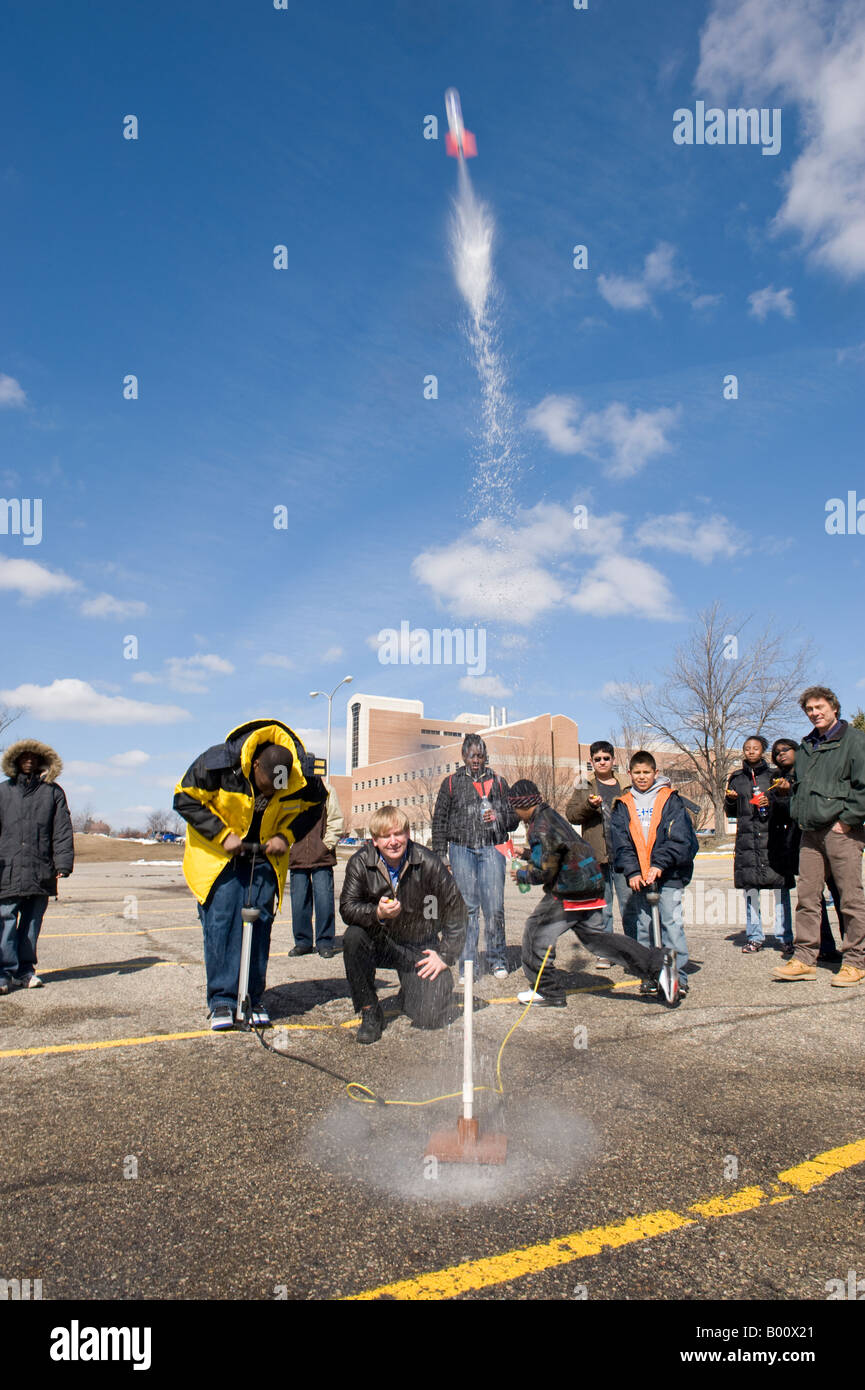 Lehrer mit Schülern starten eine Wasser angetriebene Rakete Stockfoto