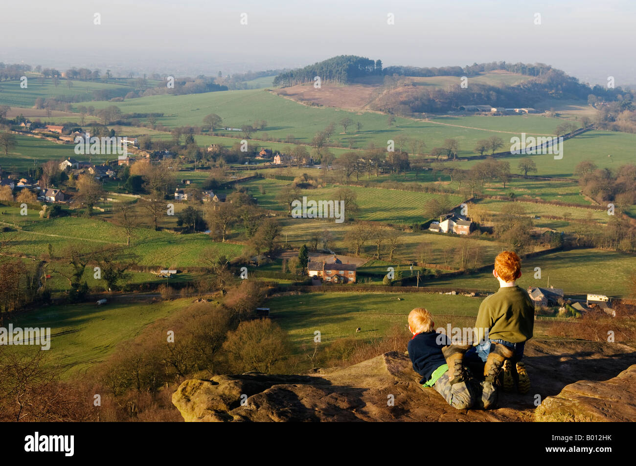 England, Cheshire, Bickerton Hils. 2 junge Besucher genießen die Aussicht über die Prärie Cheshire von den Klippen von Bickerton. Stockfoto