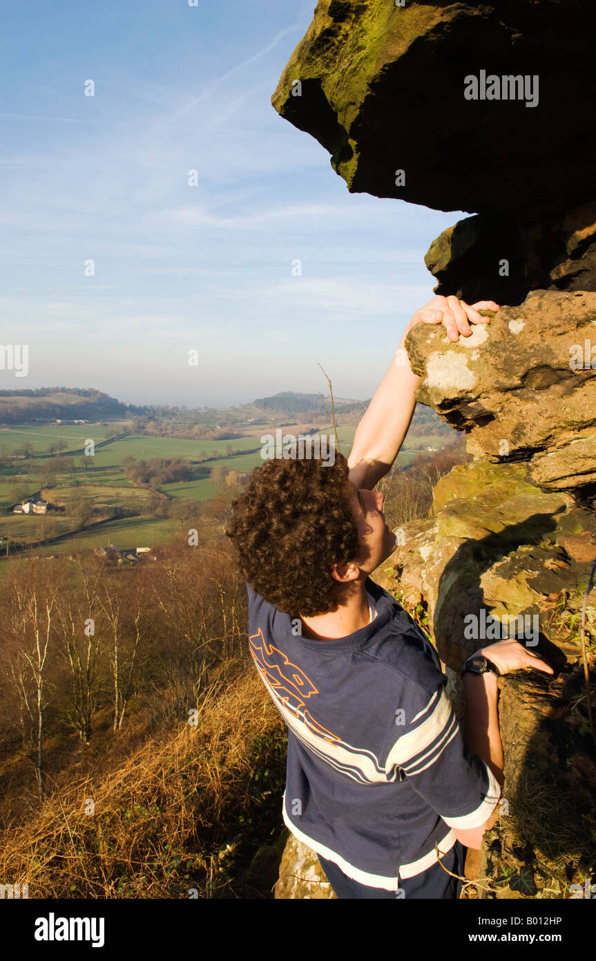 England, Cheshire, Bickerton Hils. Ein Teenager-Klettern auf die Sandsteinfelsen der Bickerton Hügel. Stockfoto