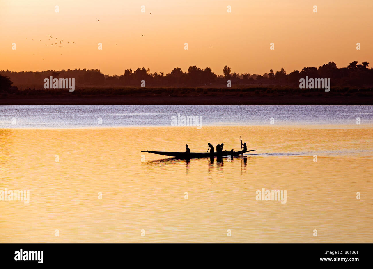 Mali, Mopti. Bei Sonnenuntergang Fähren ein Fährmann in einer Piroge Passagiere über den Fluss Niger, Mopti. Stockfoto
