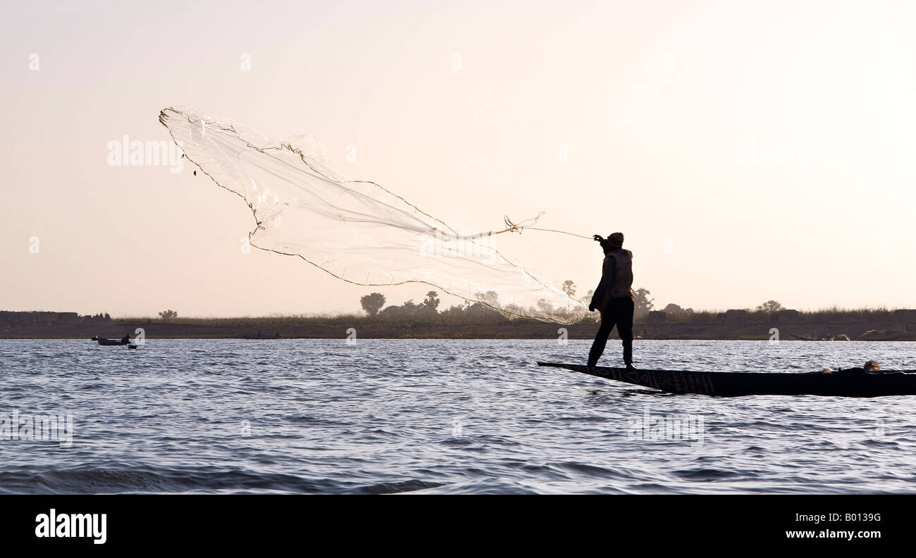 Mali, Niger-Binnendelta. In der Abenddämmerung wirft Bozo Fischer sein Netz des Niger-Flusses nördlich von Mopti. Stockfoto