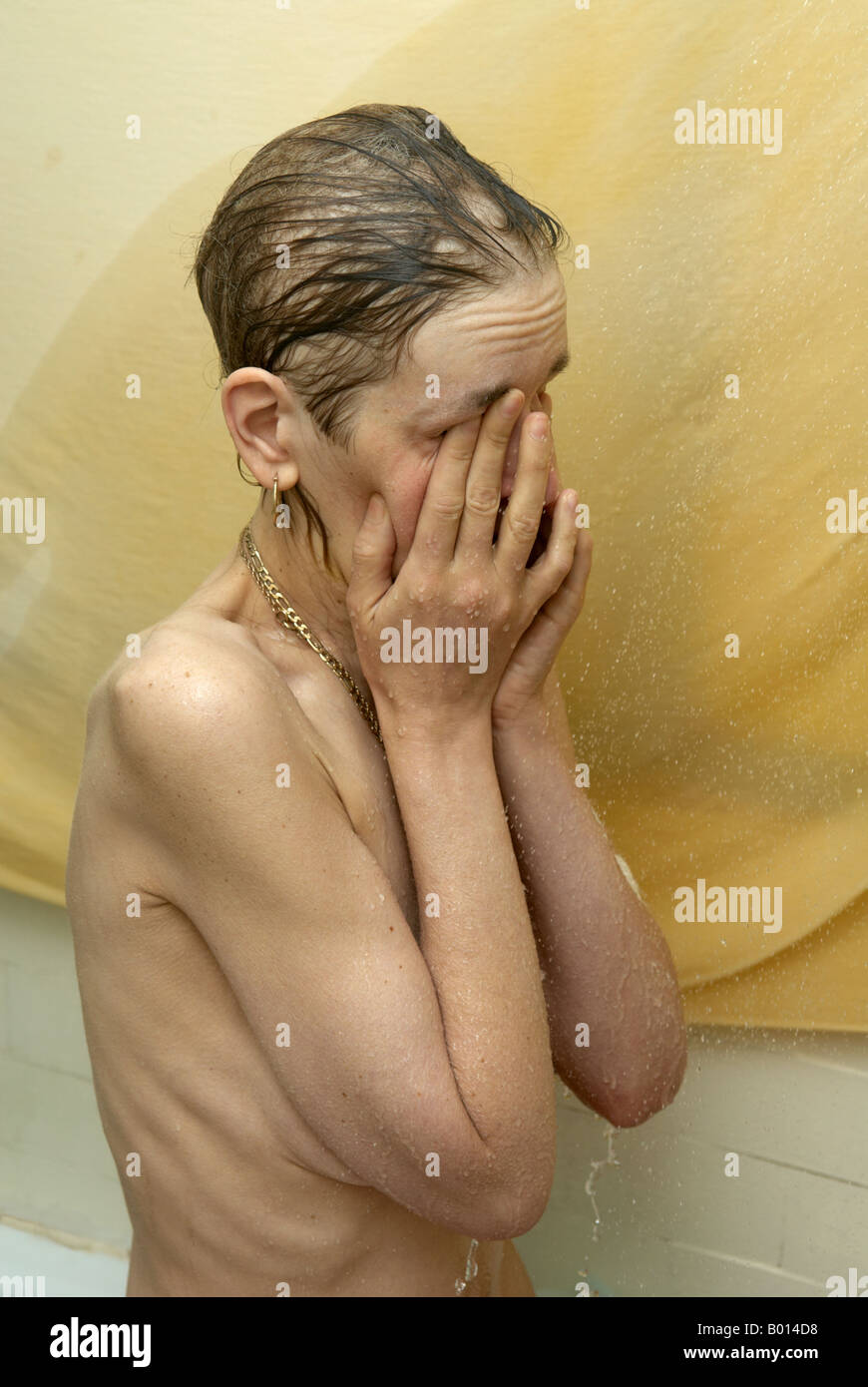 Frau mit Händen über das Gesicht - aufgrund von Chemotherapie Ausdünnen der Haare Duschen Stockfoto