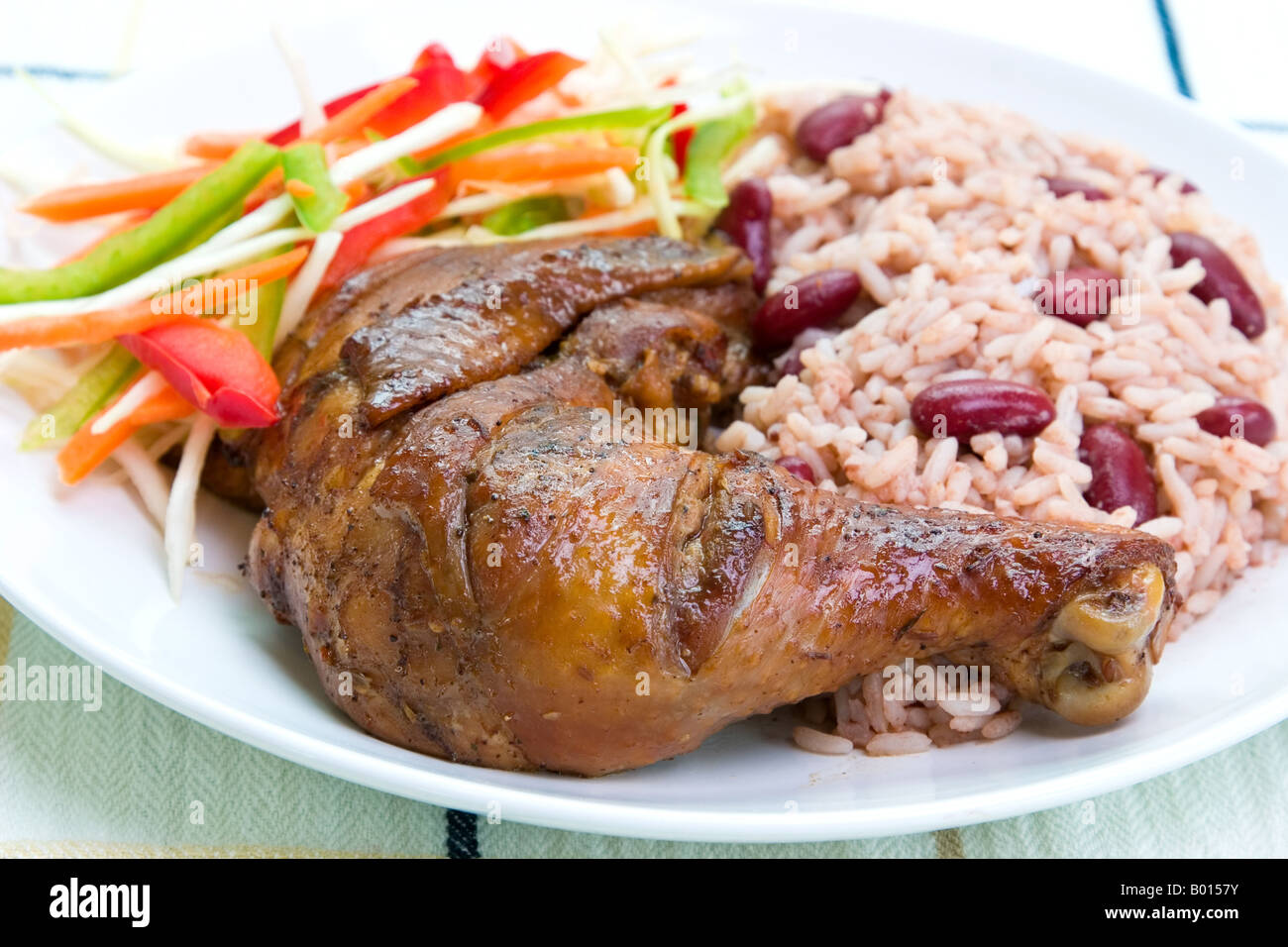 Karibischen Stil Ruckhuhn, serviert mit Reis gemischt mit roten Kidney-Bohnen Gericht begleitet mit Gemüsesalat flachen DOF Stockfoto