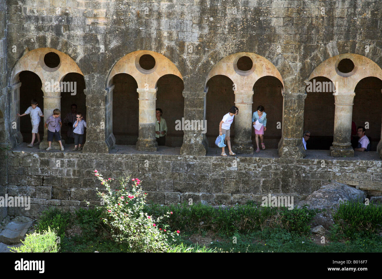 Touristen und ihre Kinder spielen in den Kreuzgängen, L'Abbaye du Thoronet, Provence, Frankreich Stockfoto