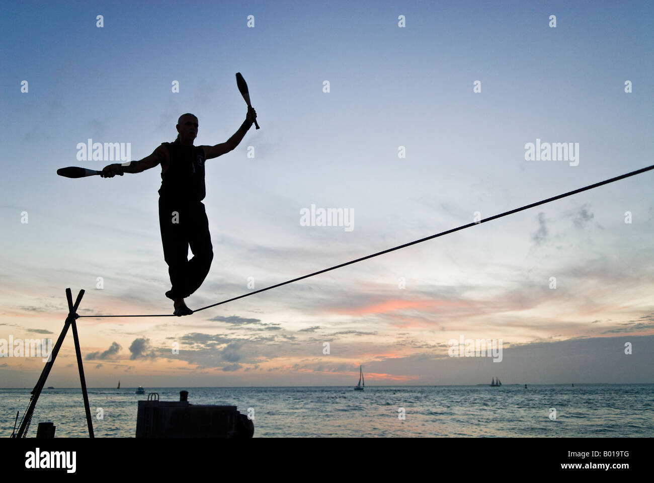 Seiltänzer jongliert über Meer bei Sonnenuntergang, Mallory Square, Key West, Florida Stockfoto