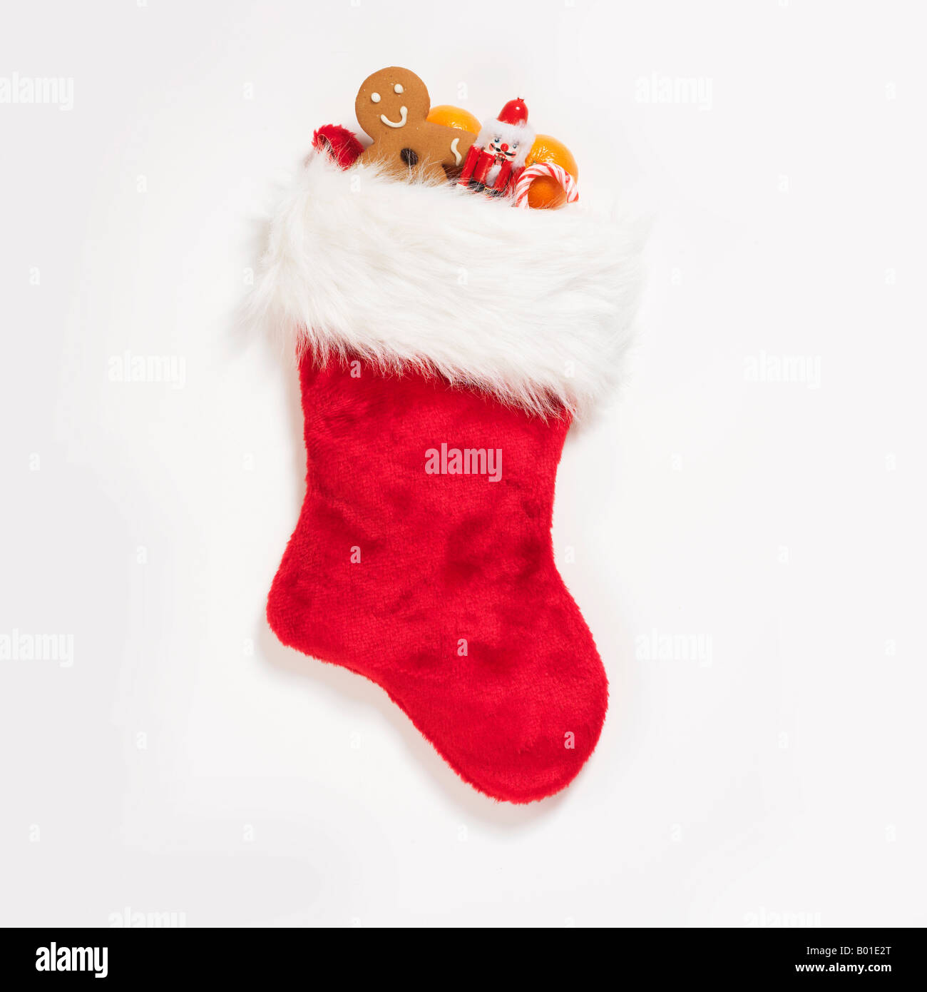 Weihnachts-Strumpf, gefüllt mit verschiedenen Leckereien und Süßigkeiten auf weißem Hintergrund Stockfoto