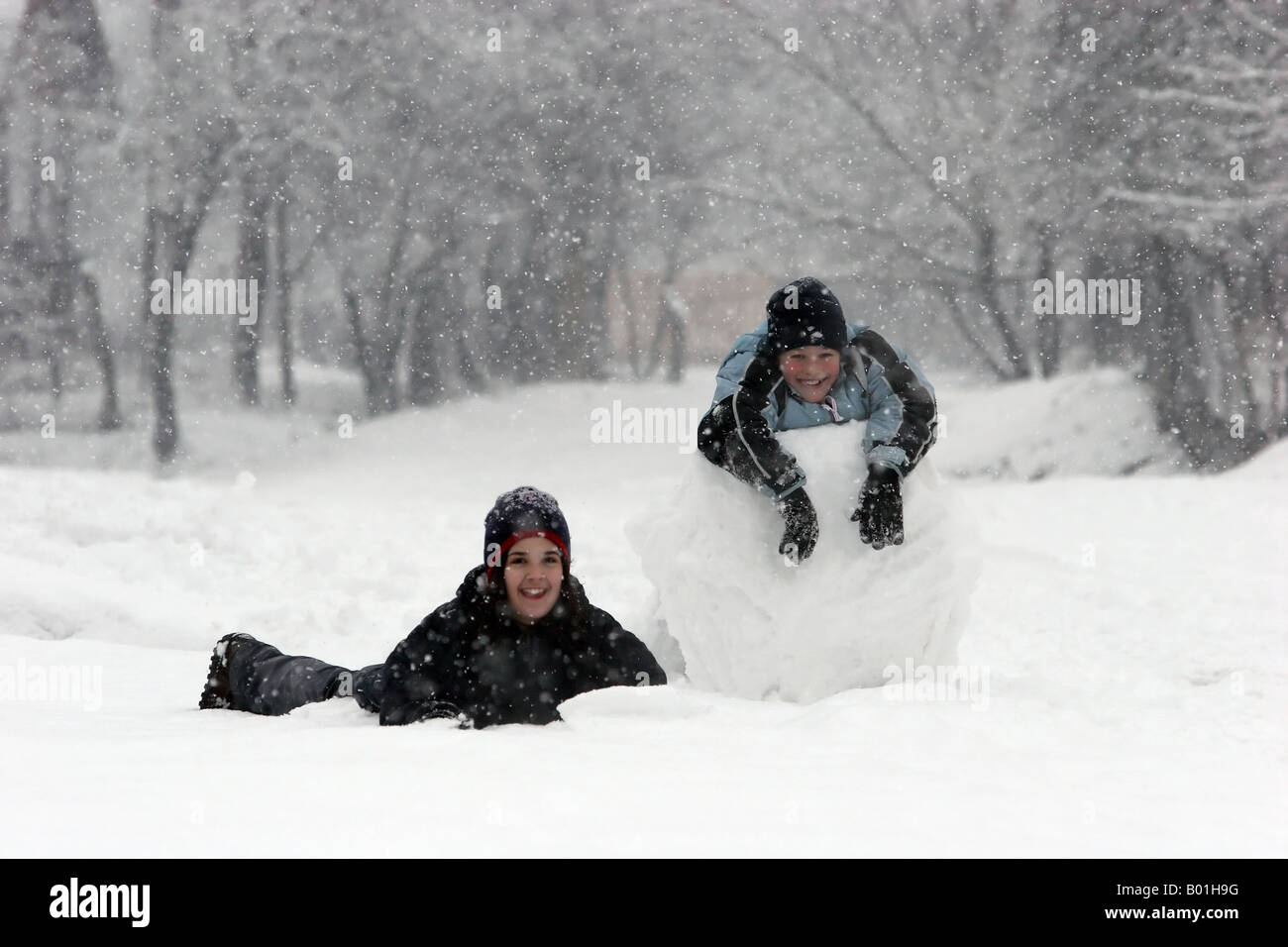 Mädchen und jungen und einer riesigen Schneekugel Stockfoto
