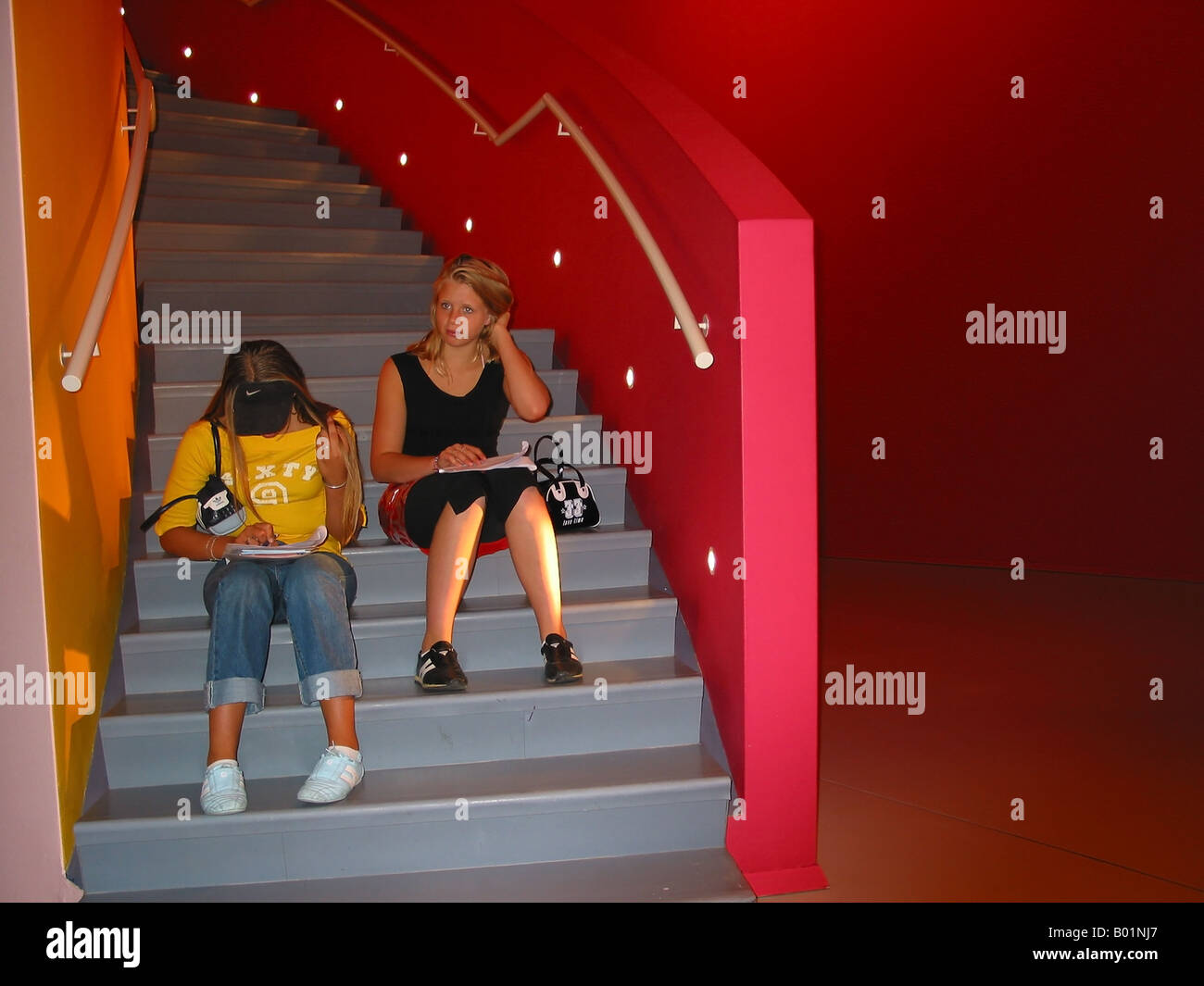 Innere des Groninger Museum Groningen Niederlande mit zwei Studenten, die Zuordnung beim Sitzen auf Schritte tun Stockfoto