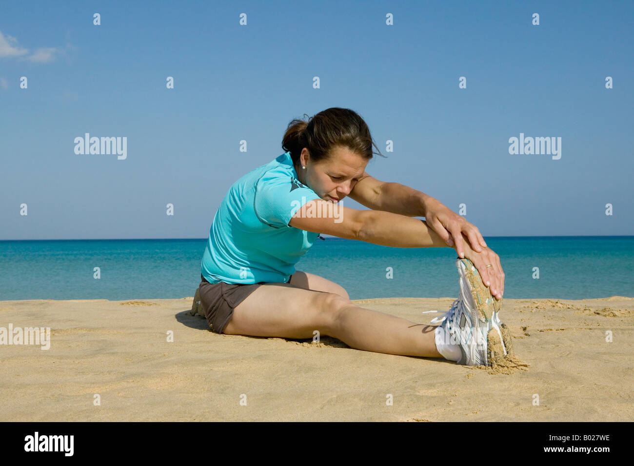 junge Frau tun stretching Übungen am Strand Stockfoto