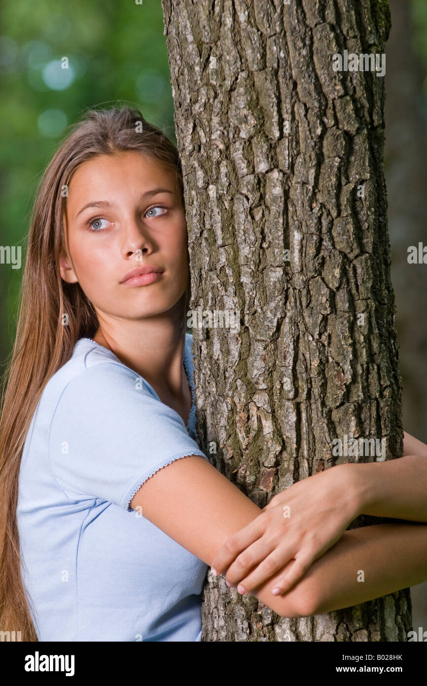 Porträt von besorgt Teenagerin Baum umarmen Stockfoto