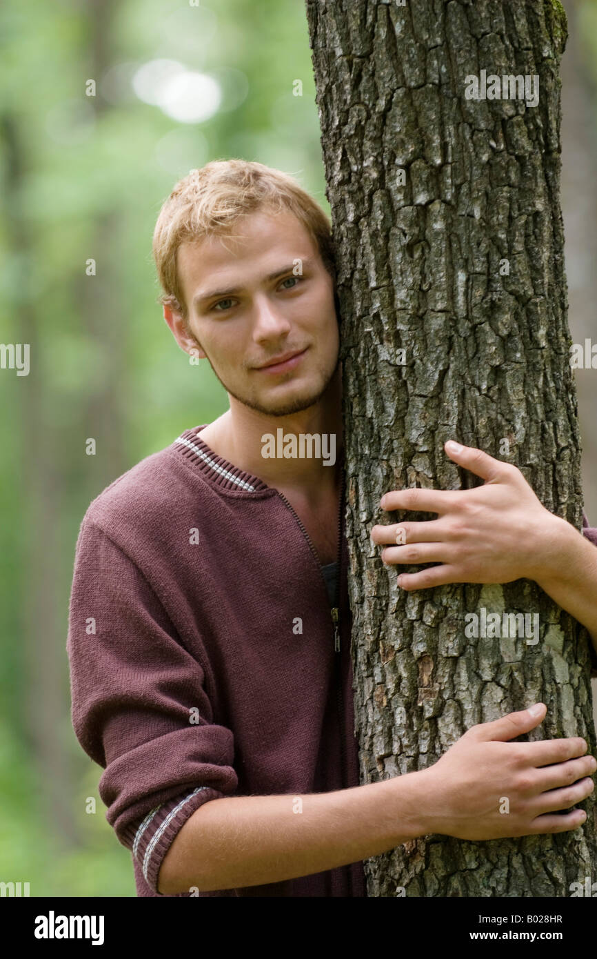 Porträt des jungen Mannes Baum umarmen Stockfoto