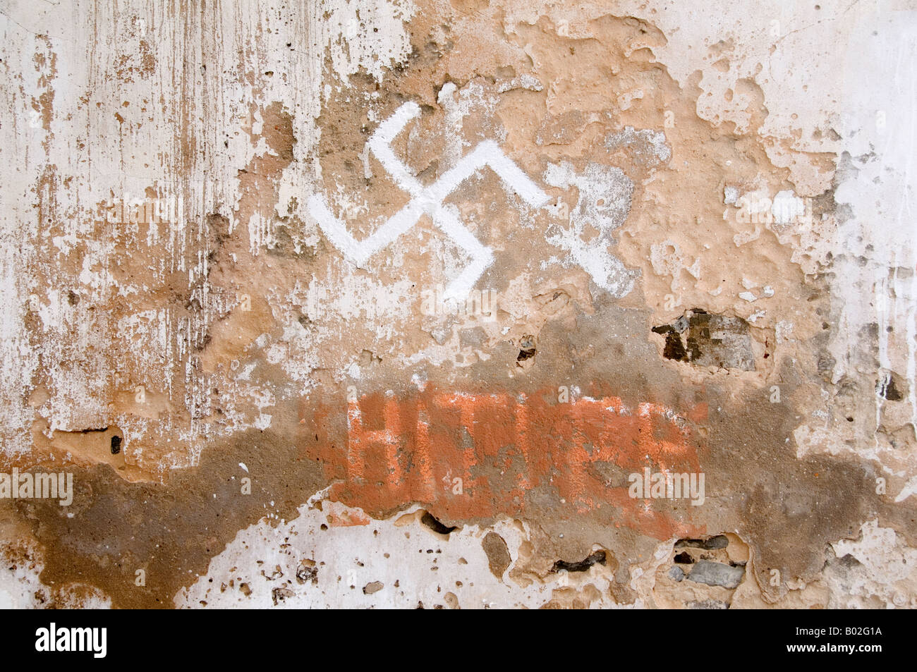Faschistischen Graffitti Hakenkreuz und Wort Hitler durchgestrichen auf alten Mauer Stockfoto