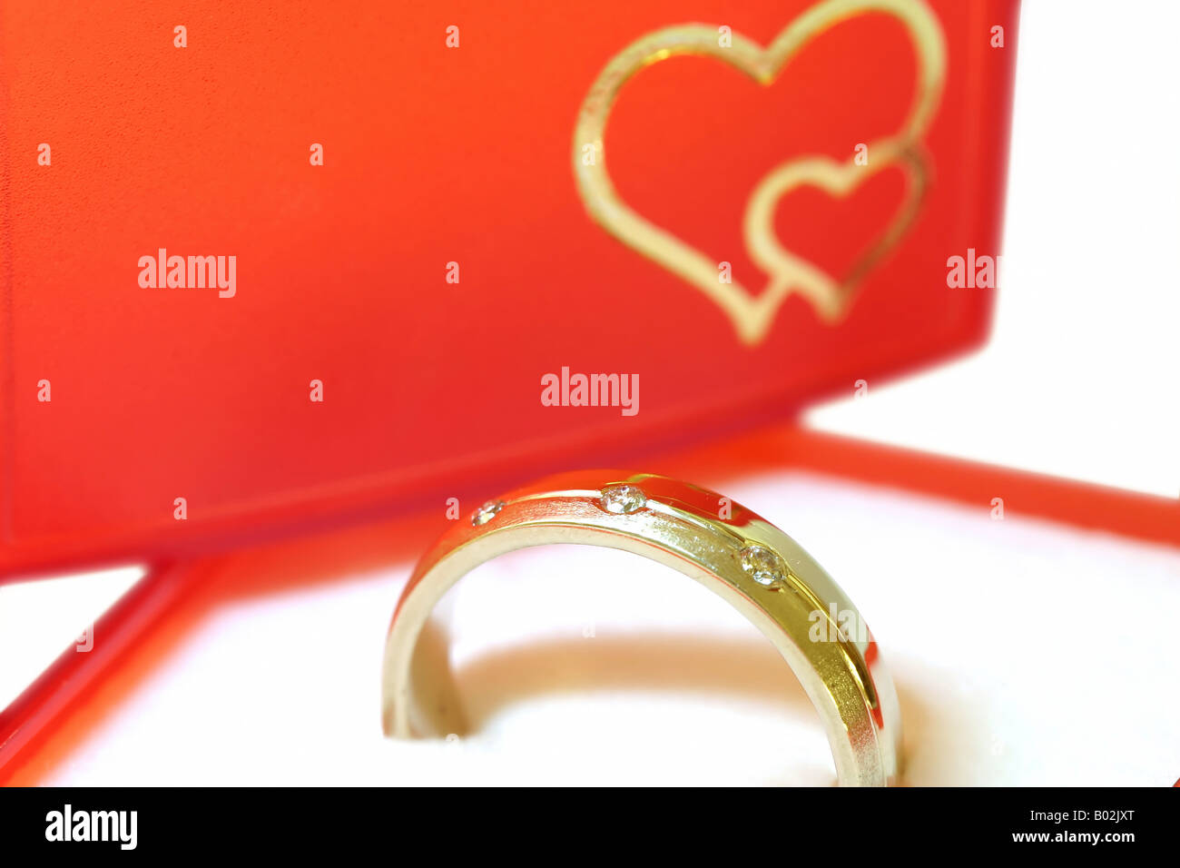 Gold Ring mit drei Brillanten im roten Feld Stockfoto