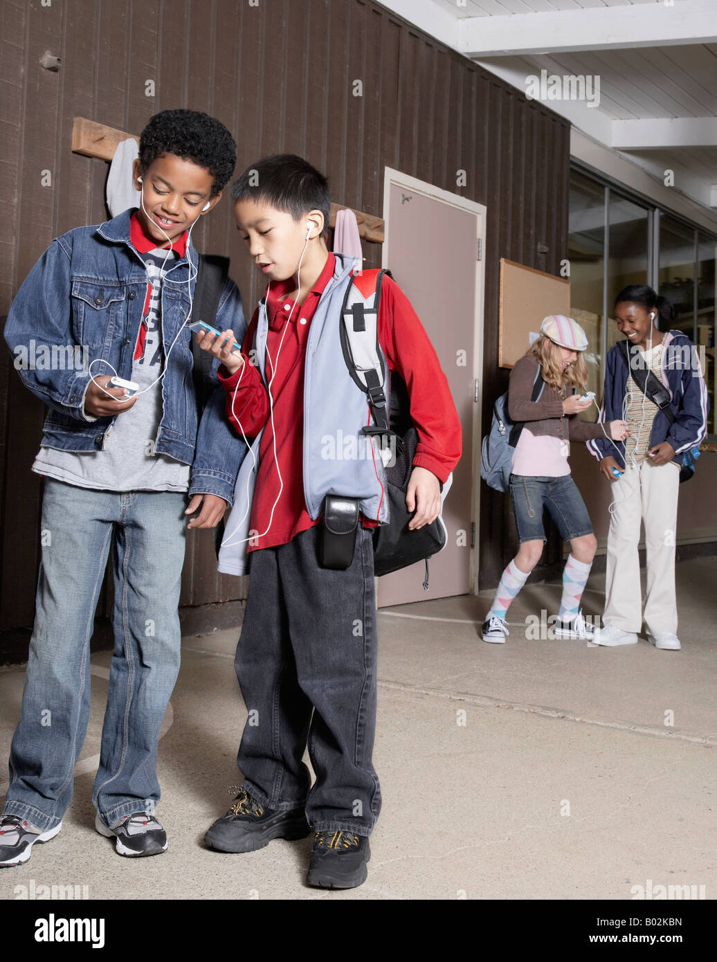 Multi-ethnischen Schulkinder anhören von MP3-Playern Stockfoto