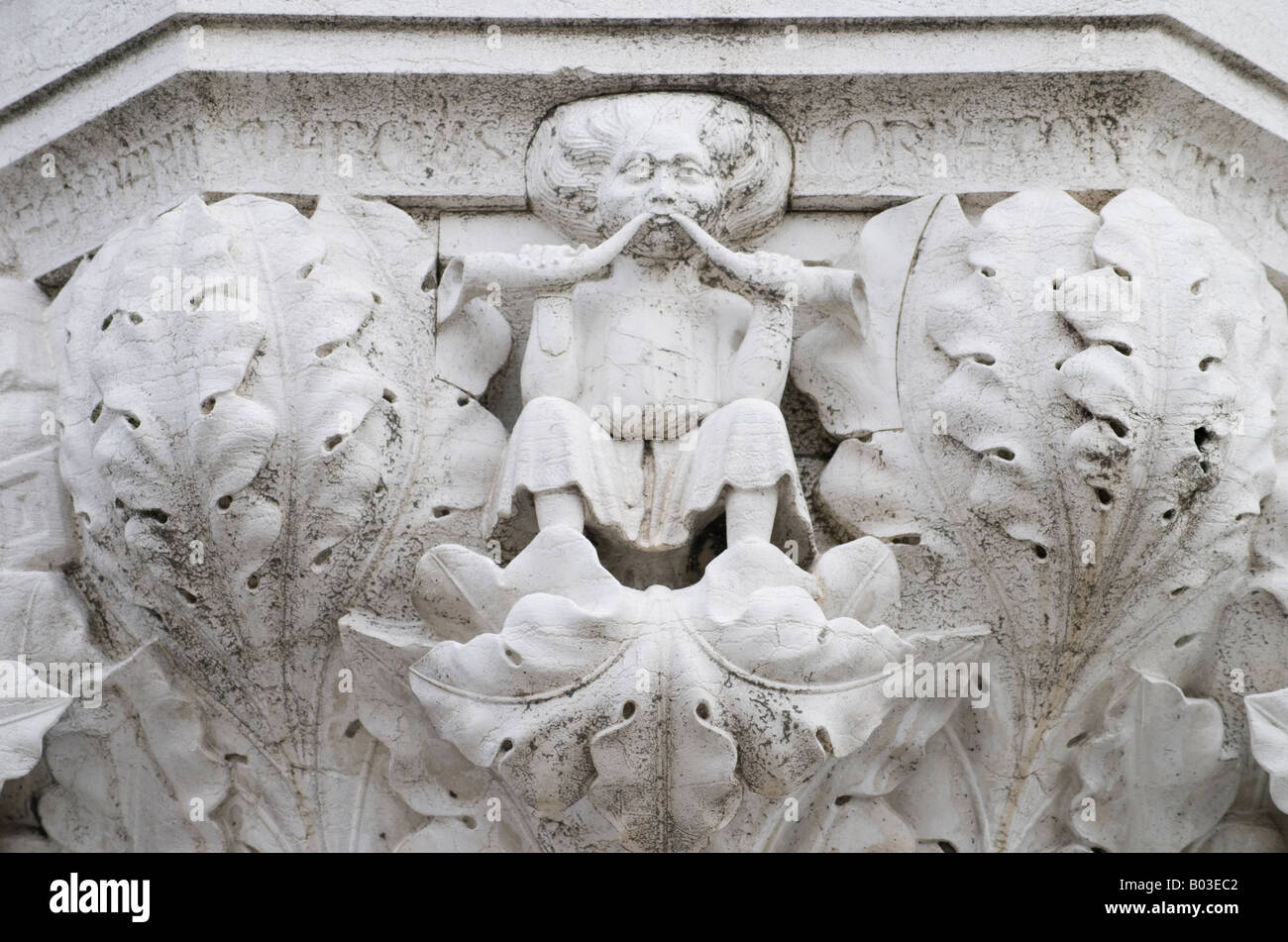 Venedig, Veneto, Italien. Detail von der Spitze einer Säule aus den Bögen des Portikus zeigt Figur mit zwei Flöten Stockfoto