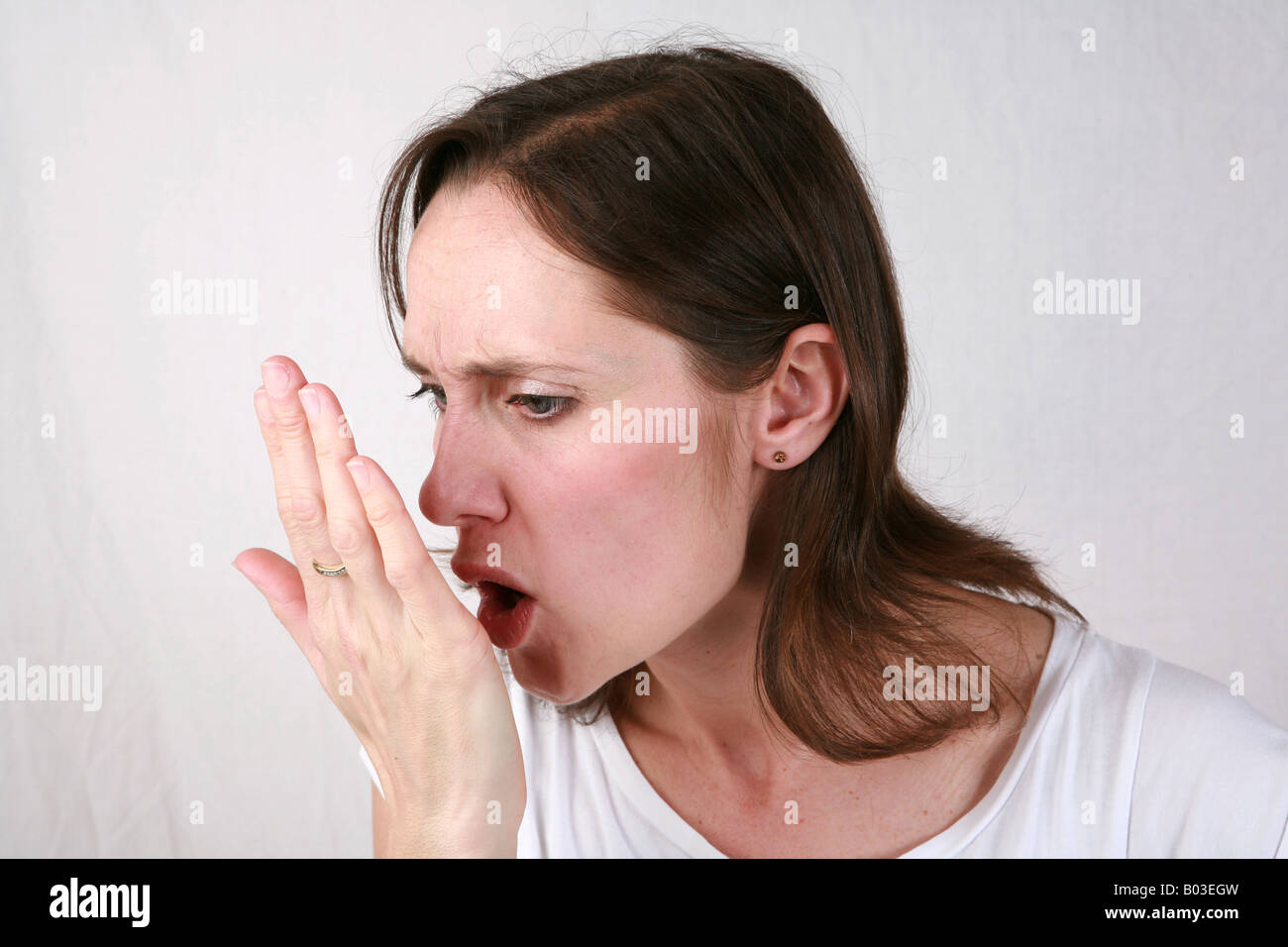 Junge Frau atmet auf Handfläche Mundgeruch Mundgeruch veraltete schlecht riechenden Atem schlechte persönliche Mundhygiene wird gesucht Stockfoto