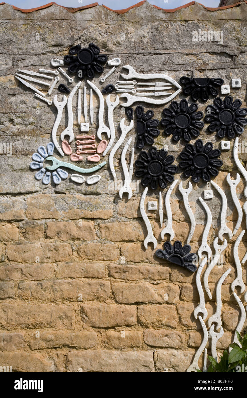 Kuh-Skulptur von alten landwirtschaftlichen Geräten an Wand in Nocton Dorf Lincolnshire England Stockfoto