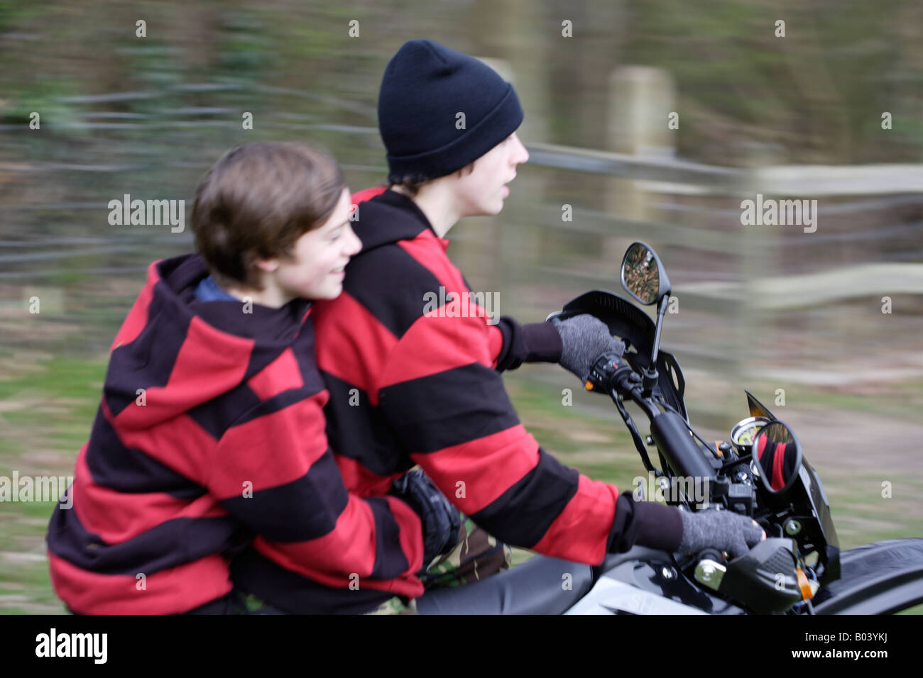 Zwei jungen auf einem Motorrad in einem Feld Stockfoto