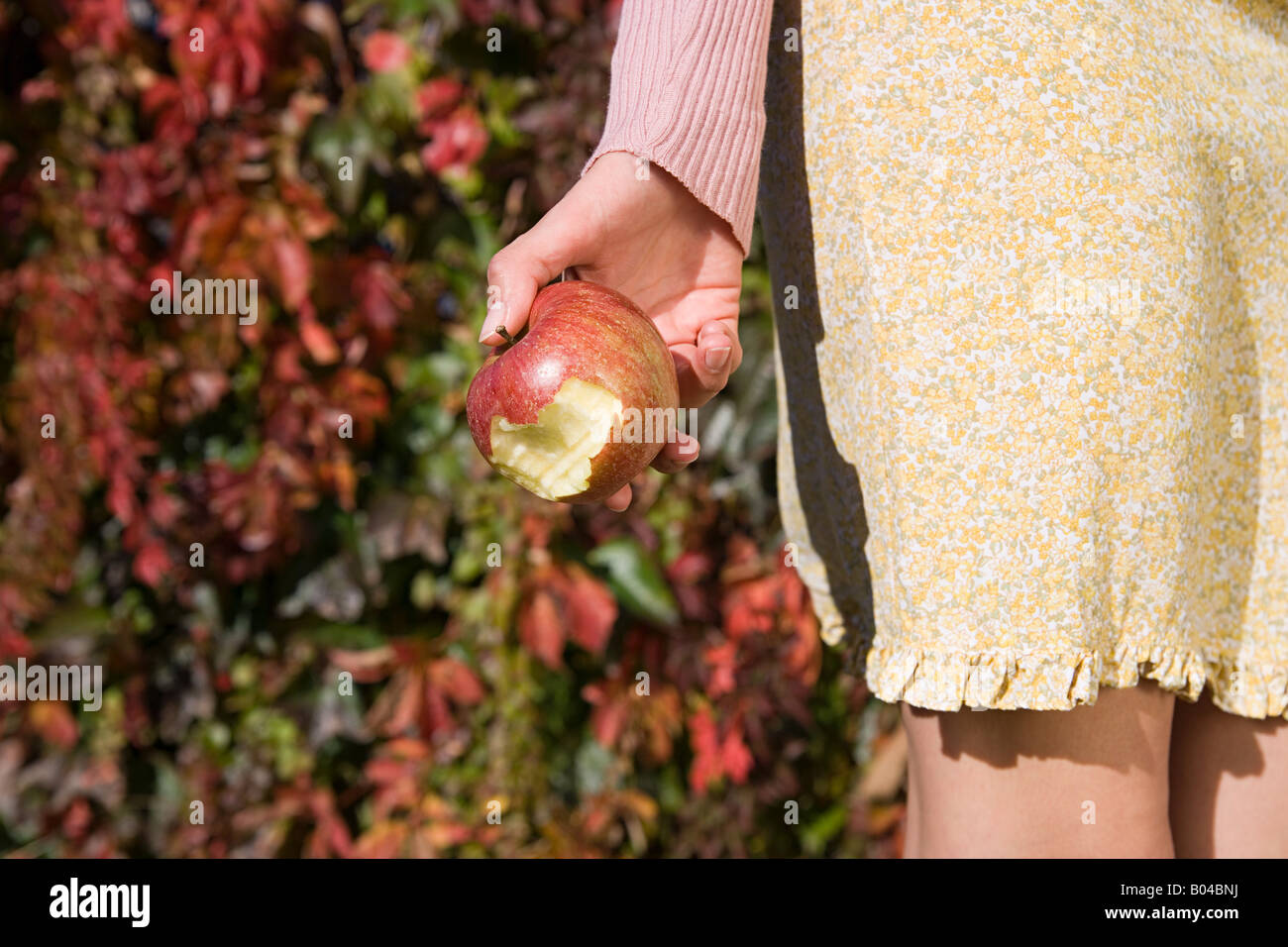 Frau hält einen angebissene Apfel Stockfoto