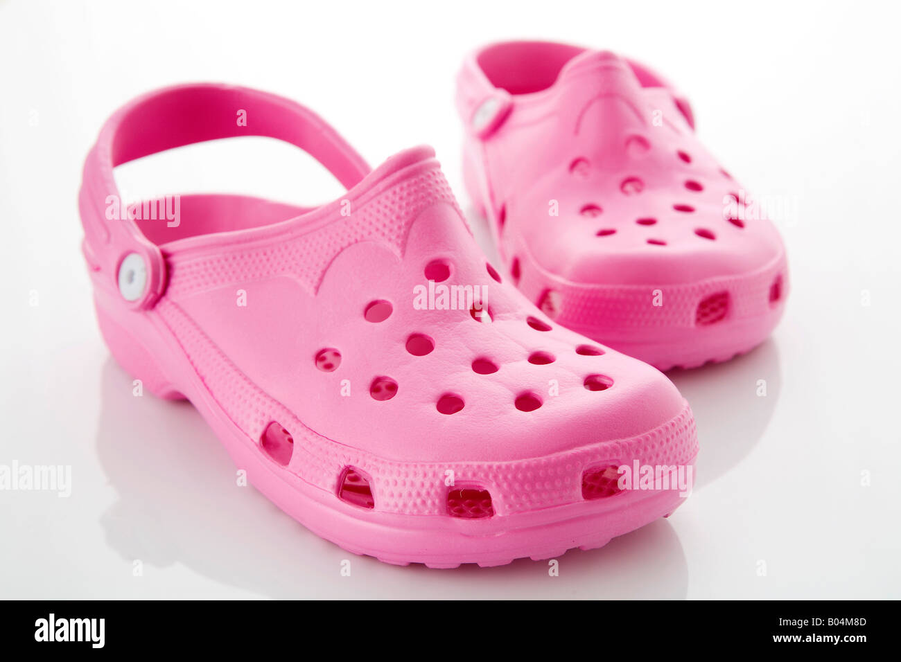 Paar rosa Kautschuk Crocs. Stockfoto