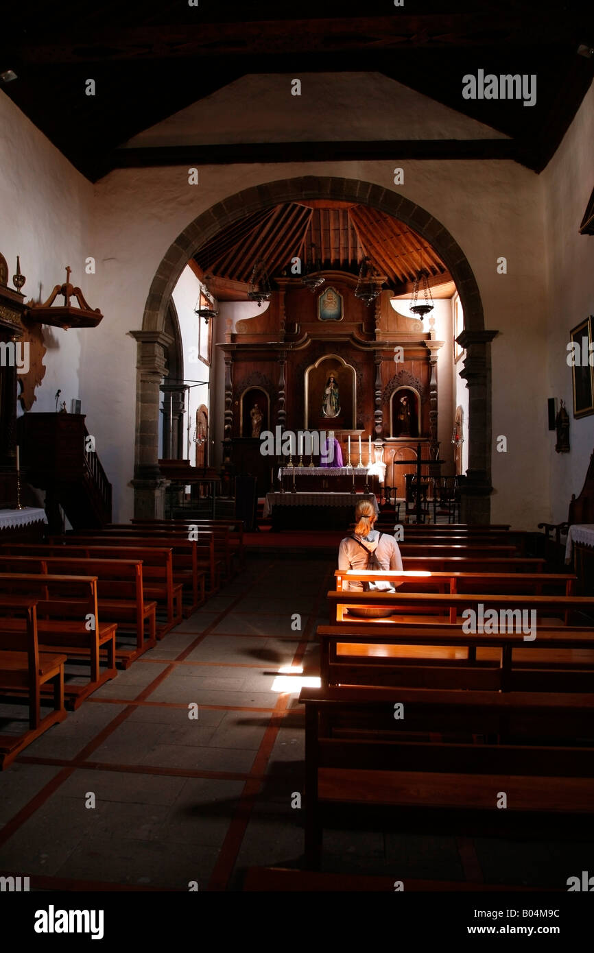 Sonnenstrahl auf Frau sitzt in einer Bank in San Pedro Church, Vilaflor, Teneriffa Stockfoto