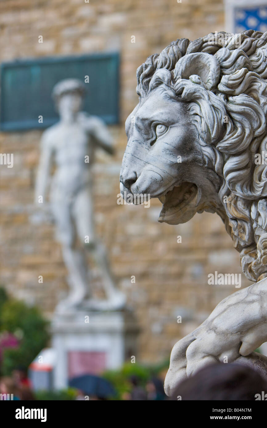 Löwenstatue mit der David-Statue im Hintergrund außerhalb Palazzo Vecchio auf der Piazza della Signoria Stockfoto