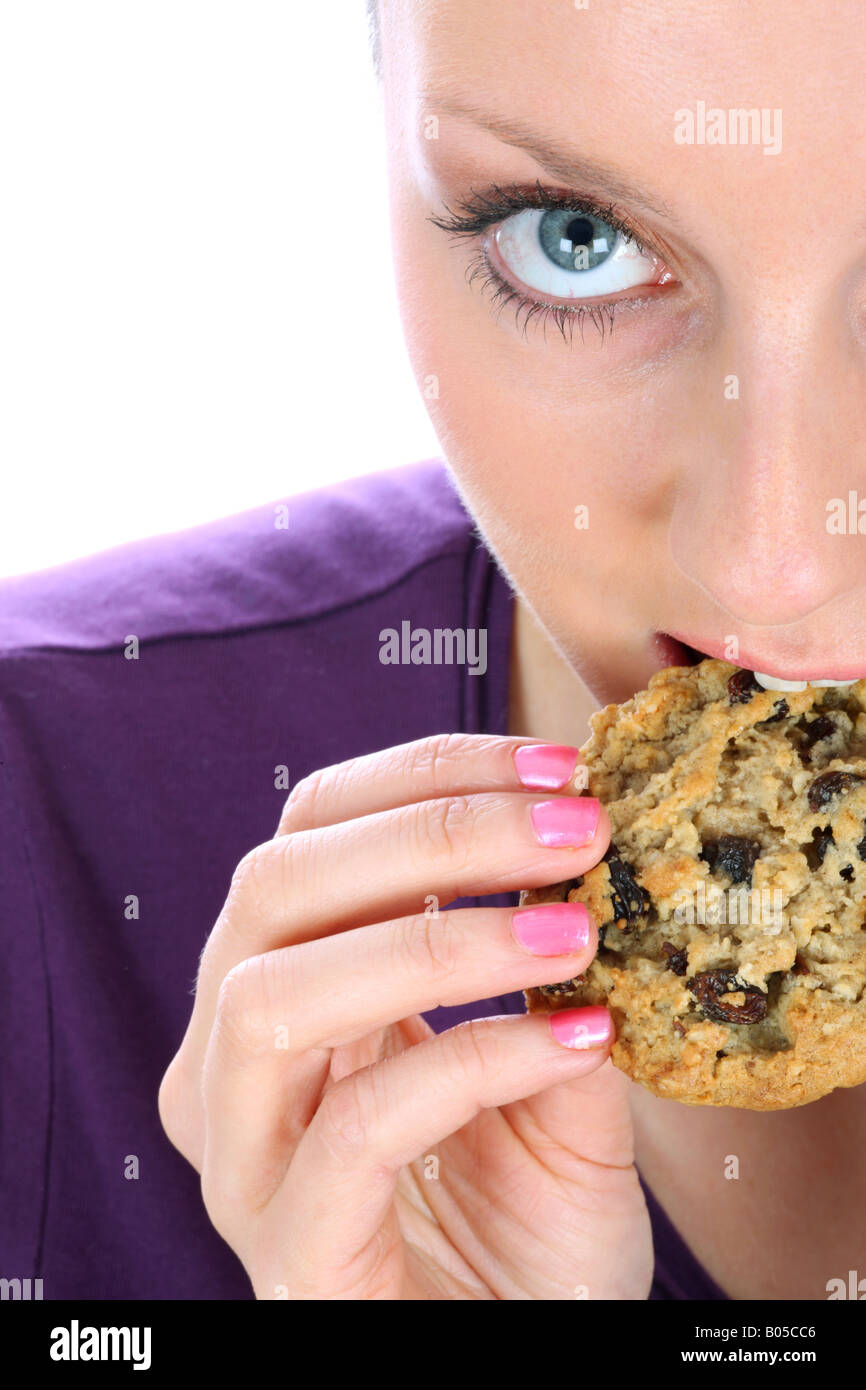 Junge Frau Essen Haferflocken und Rosinen-Cookie-Modell veröffentlicht Stockfoto