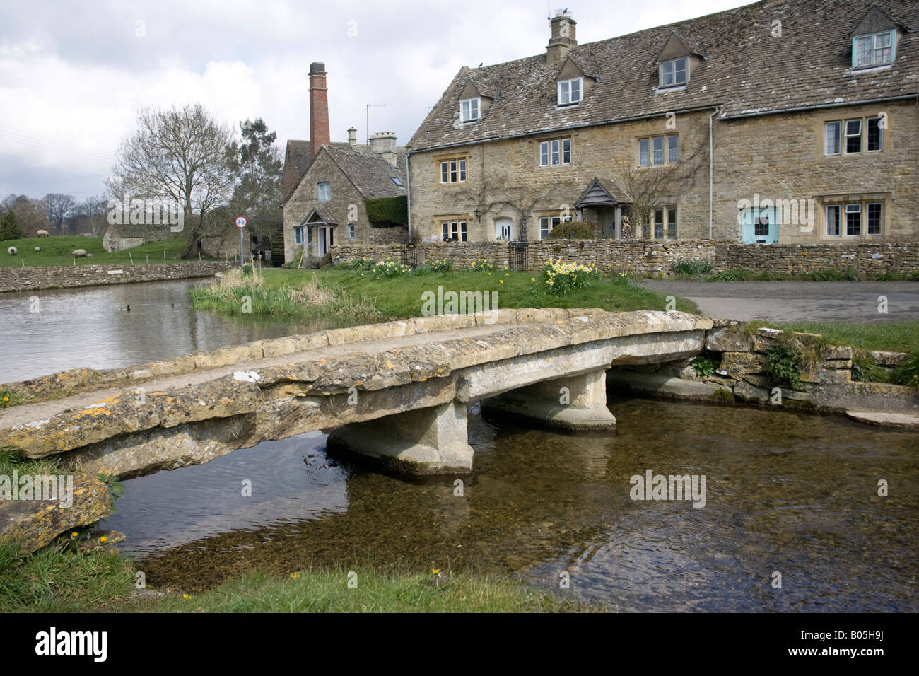 Alte Steinbrücke und Cotswold Cottages von Fluss Auge niedrigere Schlachtung Gloucestershire UK Stockfoto