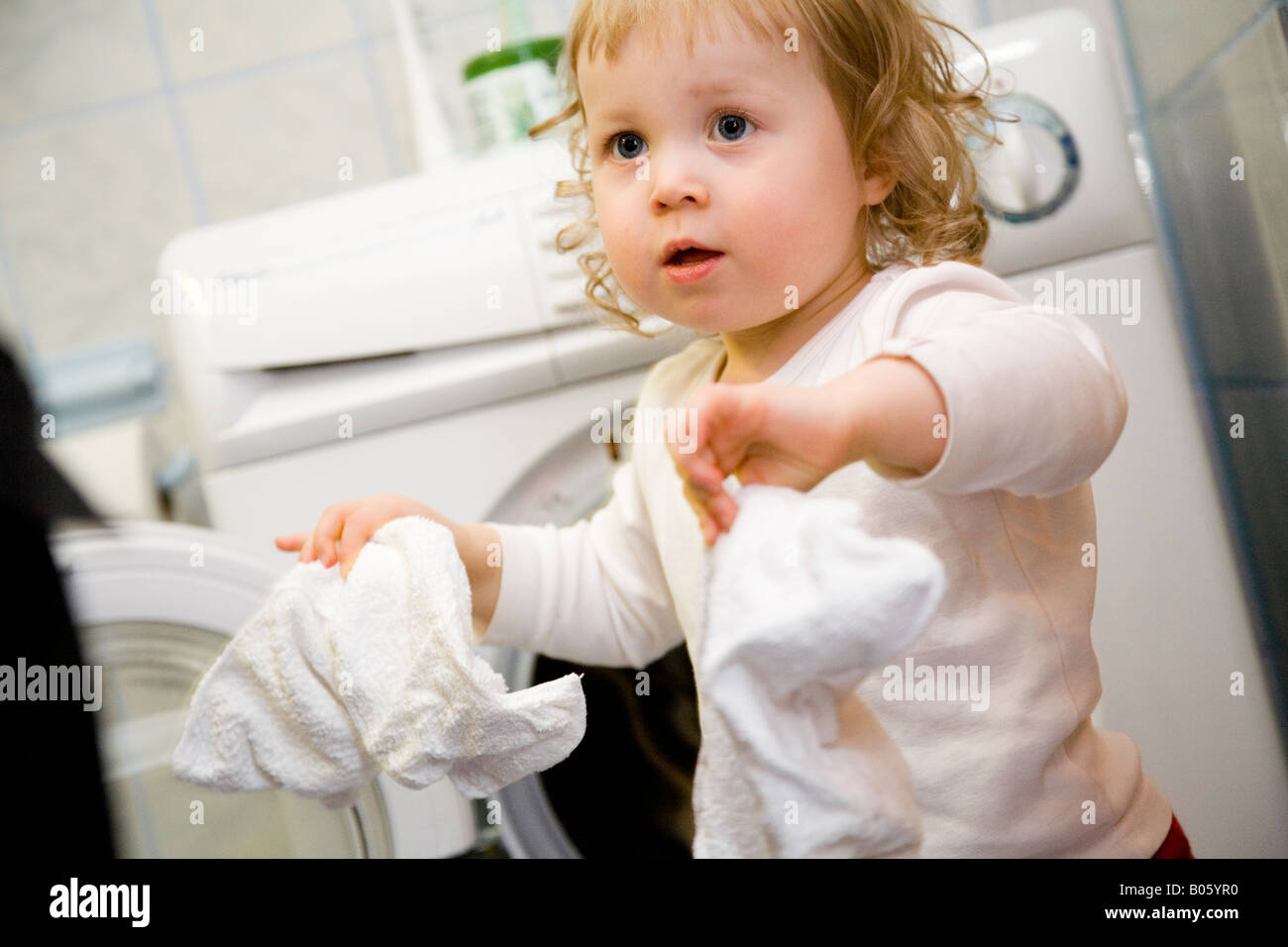 Nahaufnahme eines Mädchens hält ein Taschentuch und stand vor einer  Waschmaschine Stockfotografie - Alamy
