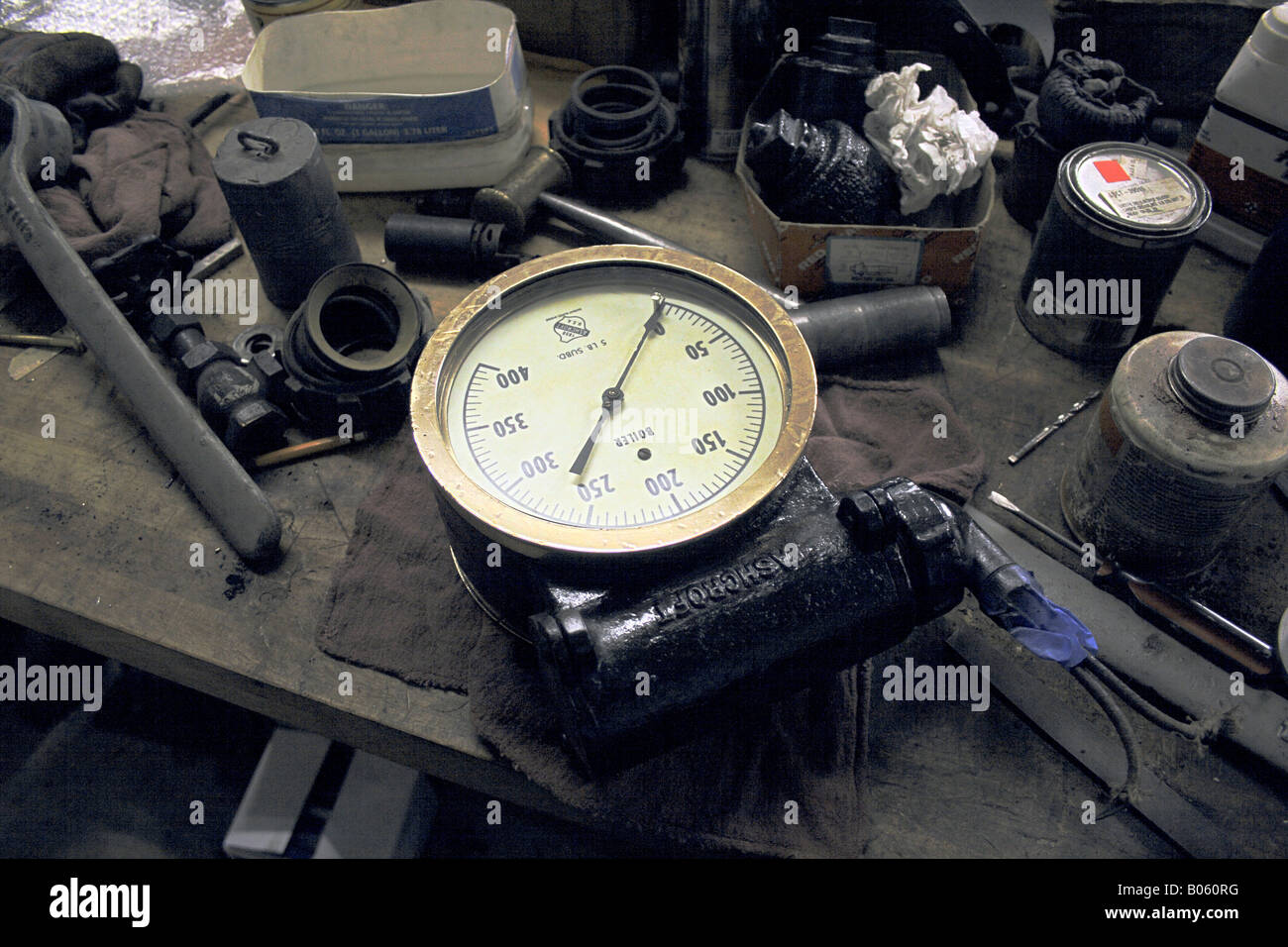 Schmutzige Werkbank mit Werkzeuge, Dosen und sonstige Gegenstände eine Messuhr Ashcroft Kessel Druck. Stockfoto
