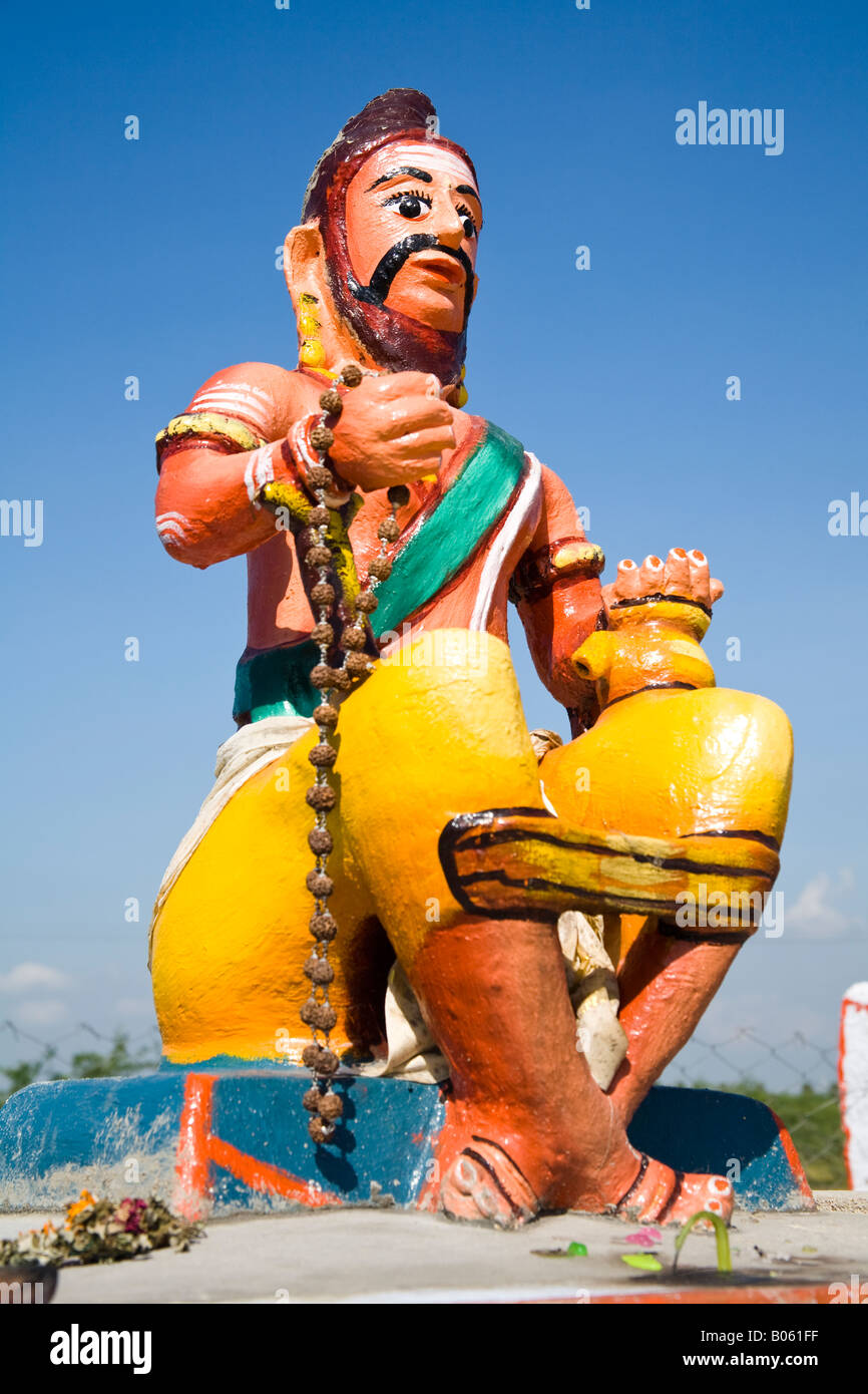 Bunte religiöse Statue, die Mann sitzt auf der Mauer bei einem Hindu-Schrein, Tamil Nadu, Indien Stockfoto