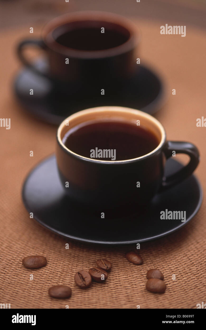 Zwei Tassen Kaffee mit Kaffeebohnen auf Tisch Stockfoto