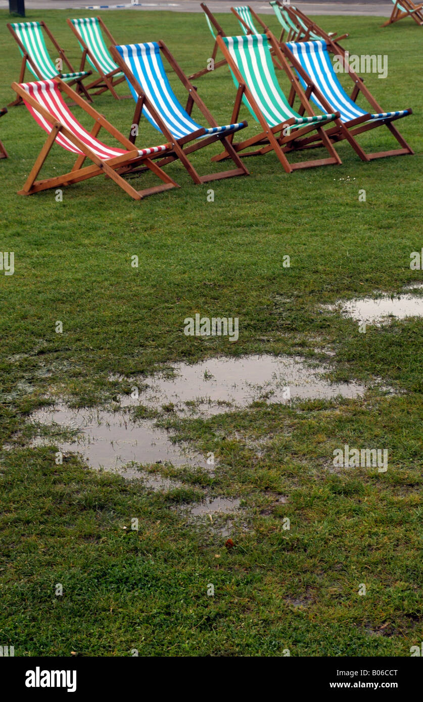 Typisch britische Sommer Parkland Szene nass Feuchte Liegestühle und Pfützen von Regenwasser Stockfoto