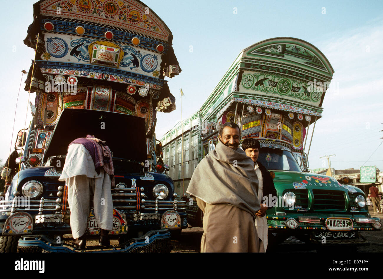 Pakistan Karachi Transport zwei Männer mit ihren dekorierten Lastwagen warten auf Benutzerdefiniert Stockfoto