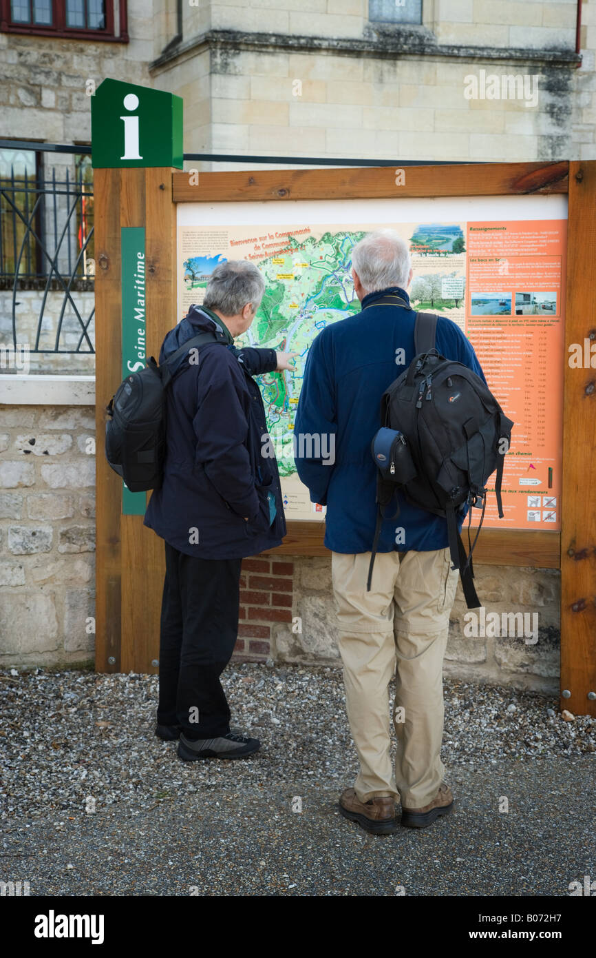 Zwei englische Touristen Blick auf eine Stadtkarte auf eine touristische Informationen außerhalb der Abbaye de Jumieges. Stockfoto